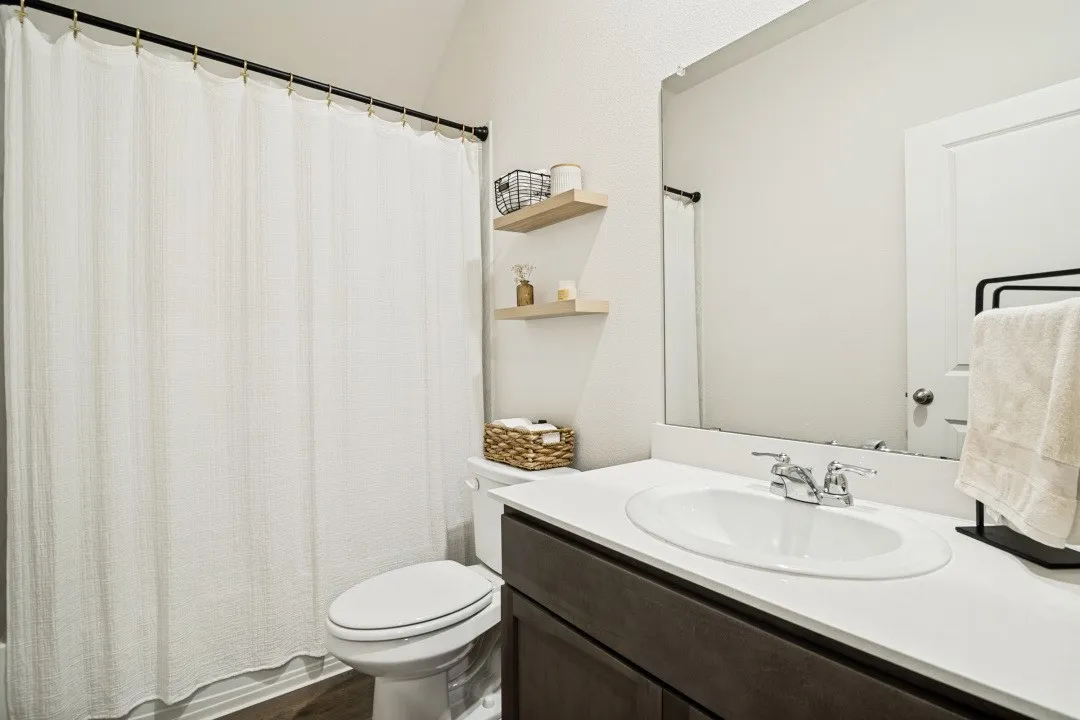 Bathroom featuring a dark wood-finish vanity with a white countertop and integrated sink