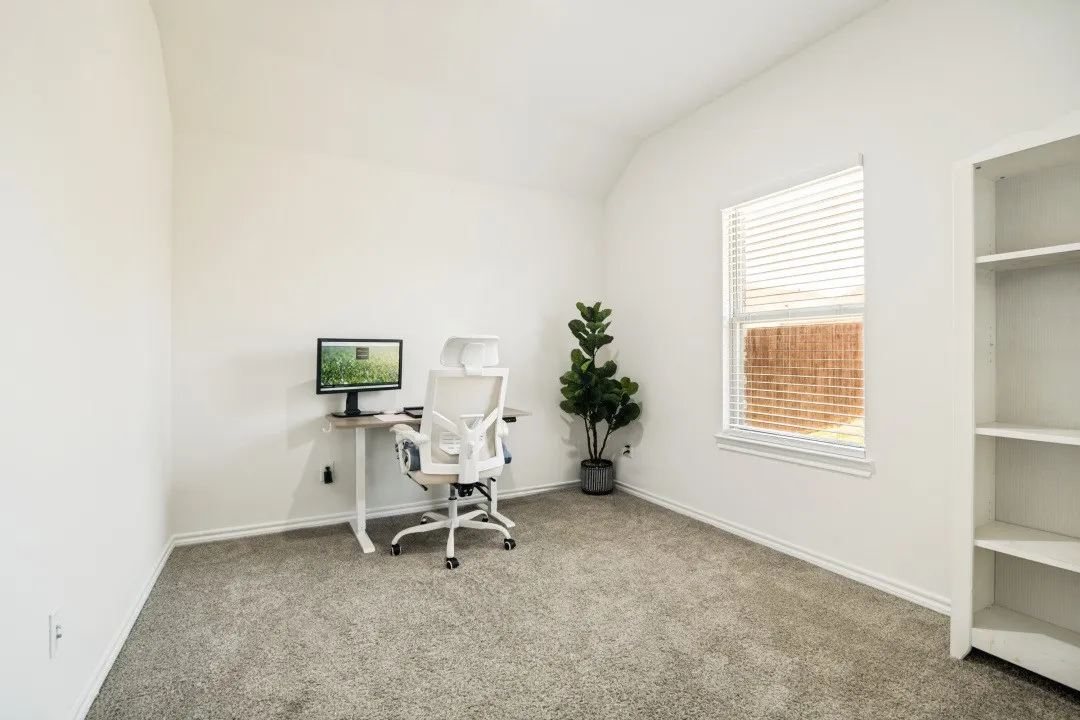 Carpeted room featuring white walls, a single window with blinds, and a built-in shelving unit