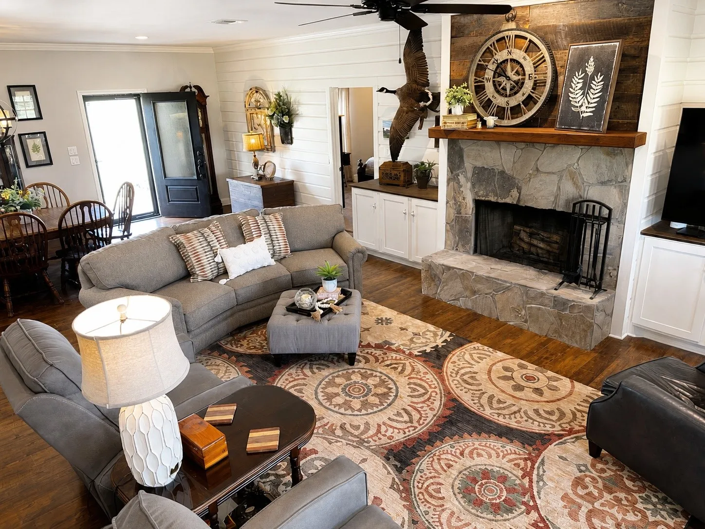 Stone fireplace with a wood mantle and plank accent wall