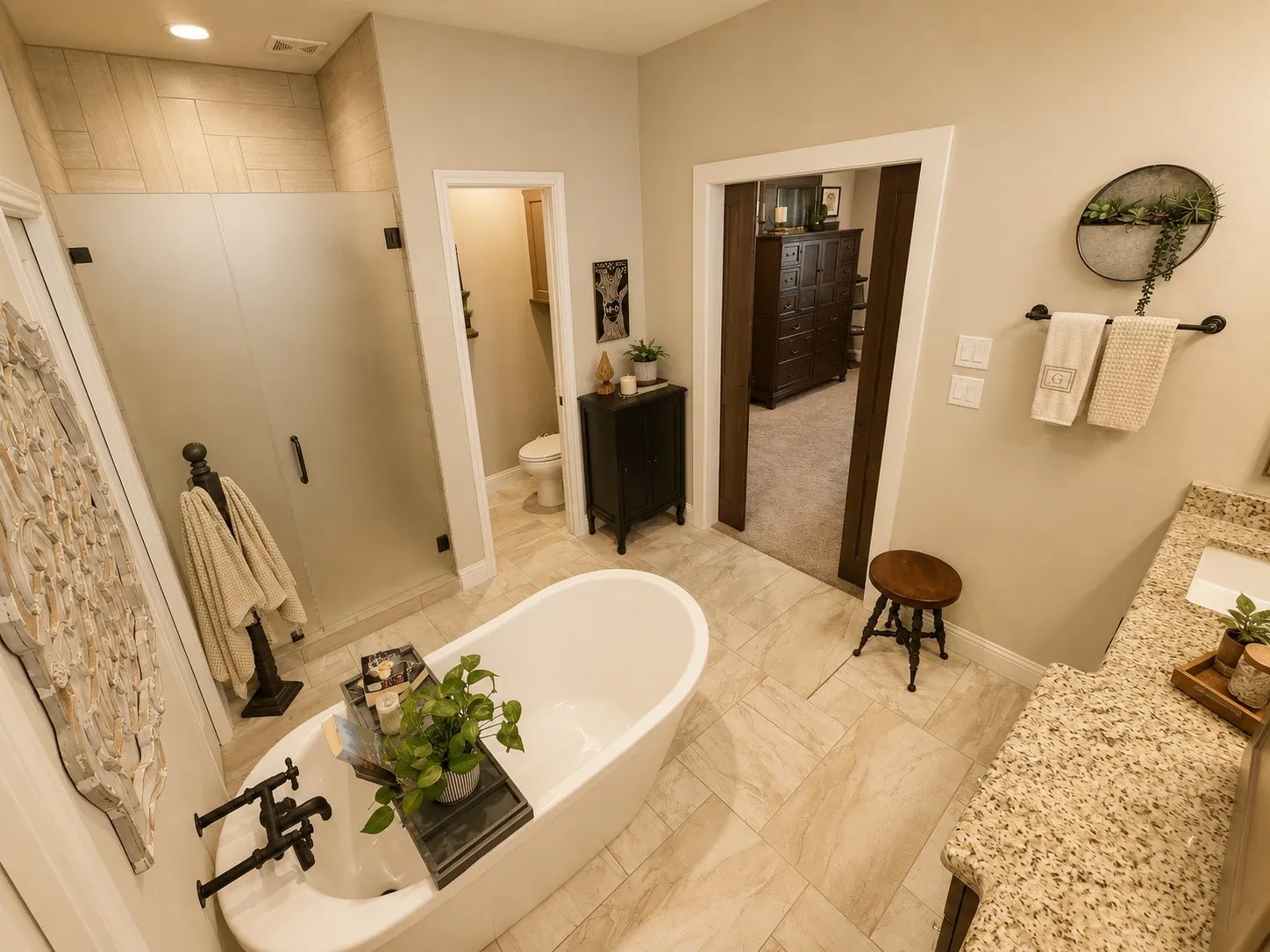 Freestanding soaking tub with matte black fixtures, set on large format tile flooring