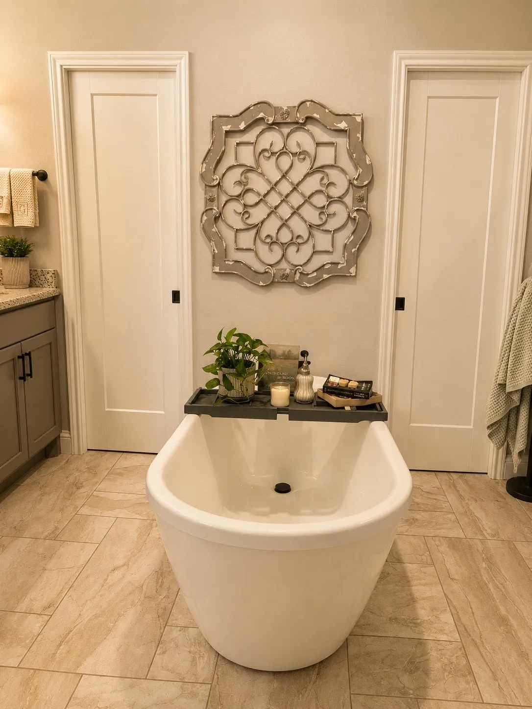 Freestanding soaking tub with tile flooring, shaker-style vanity with stone-finish countertop, and two panel doors