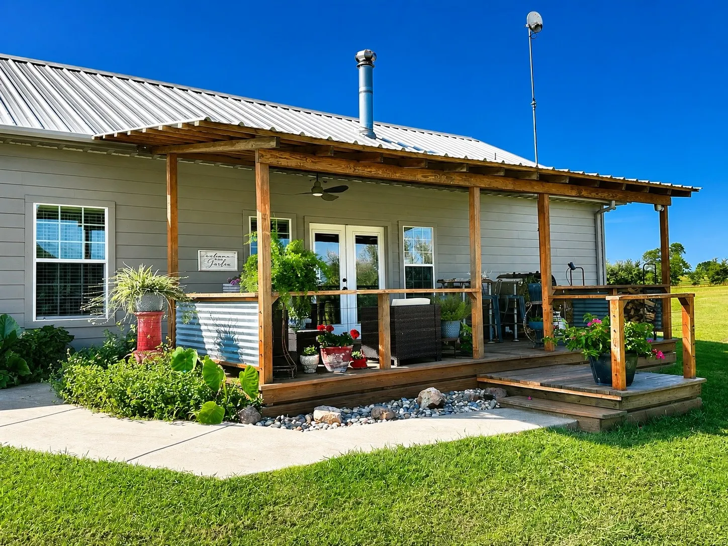 Expansive wooden deck featuring natural wood railings and a corrugated metal accent wall