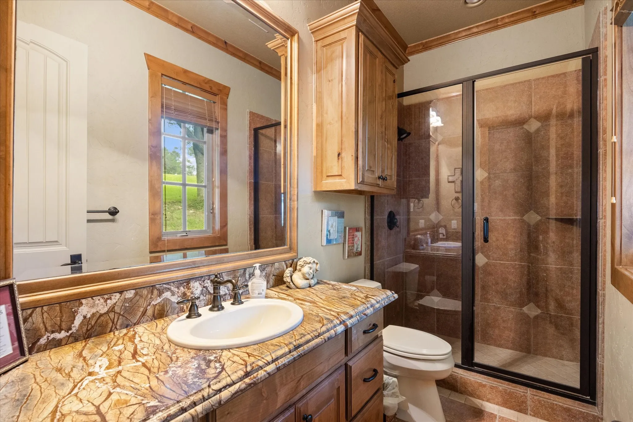 Vanity with a decorative countertop and integrated sink, complemented by natural wood-finish cabinetry