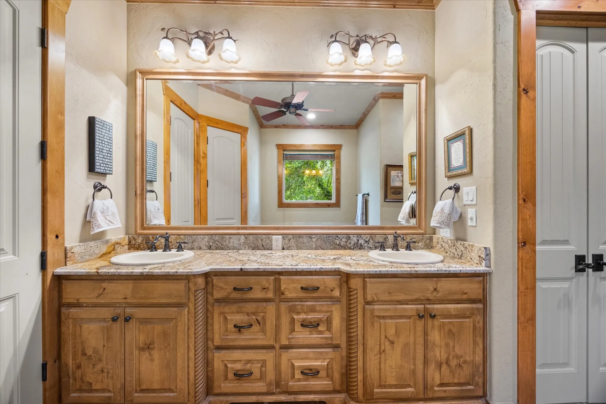 Dual vanity with stone countertop, integrated sinks, and distressed wood cabinetry