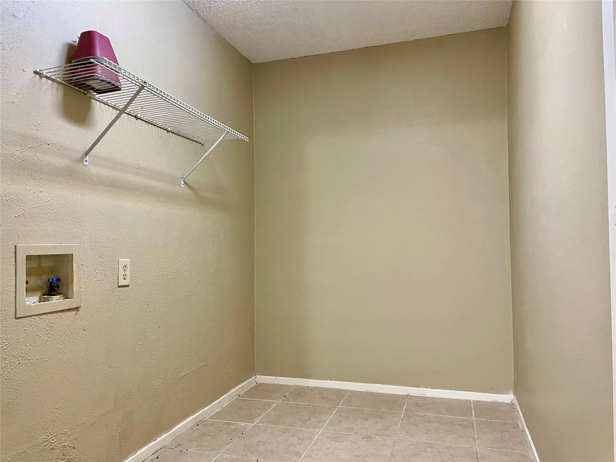 Washroom with washer hookup and light tile patterned flooring