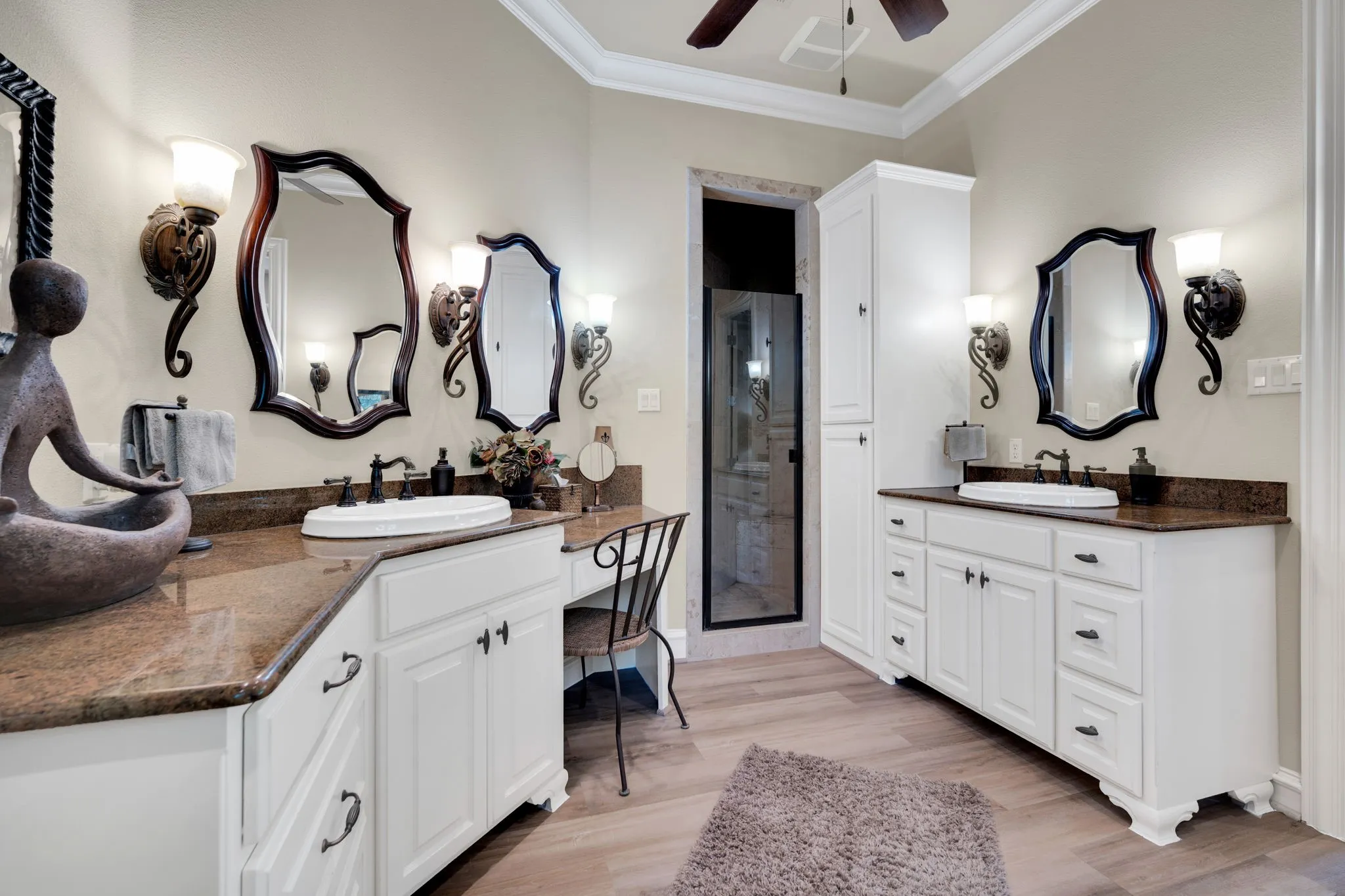 Dual vanity sinks with granite countertops and white cabinetry