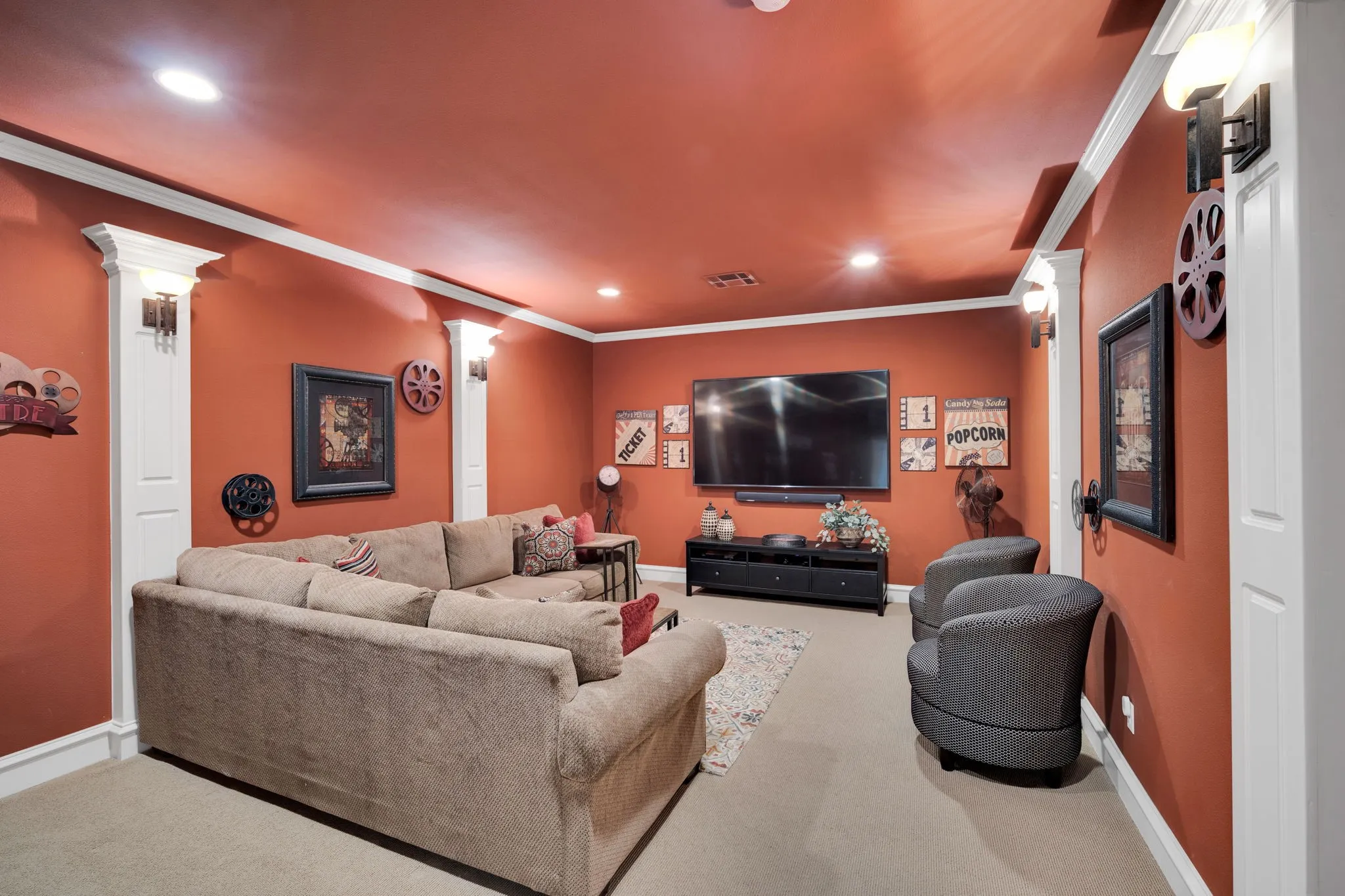 Entertainment room featuring recessed lighting, wall sconces, ceiling-mounted speakers, and a built-in media console