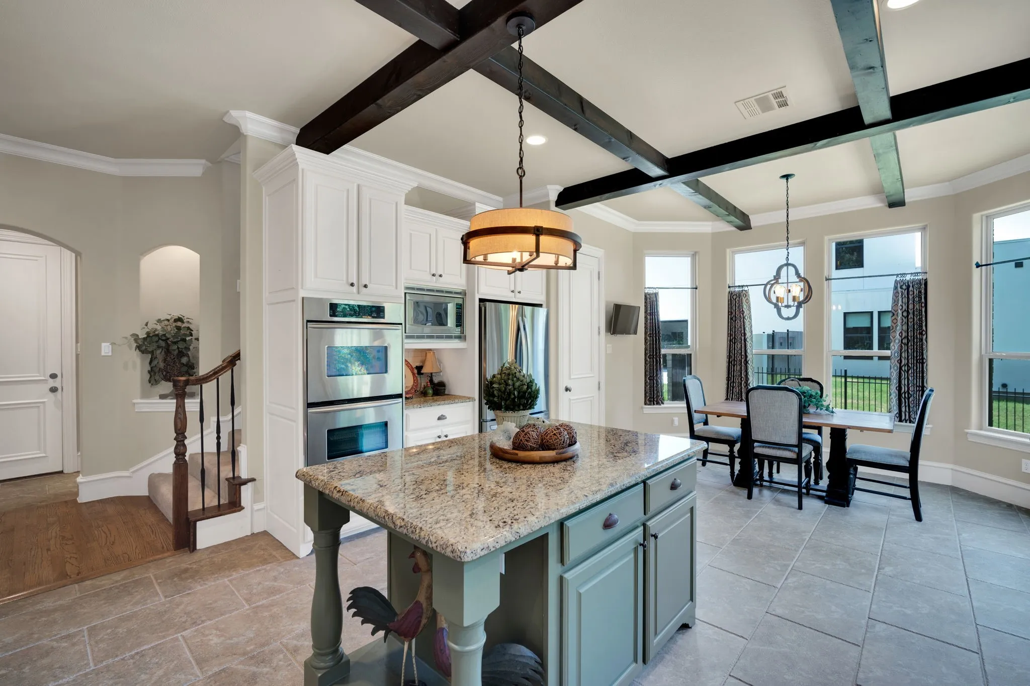 Kitchen featuring an island with a stone countertop, white cabinetry, and stainless steel built-in appliances