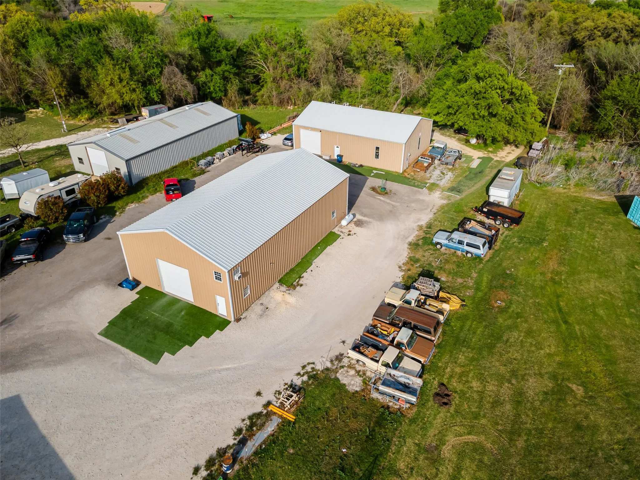 Great aerial view of property showing both metal shops. Front building measures 40 X 70 with 16 ft ceilings. The back building measures 10 X 10 with one 12 X 12 overhead door.