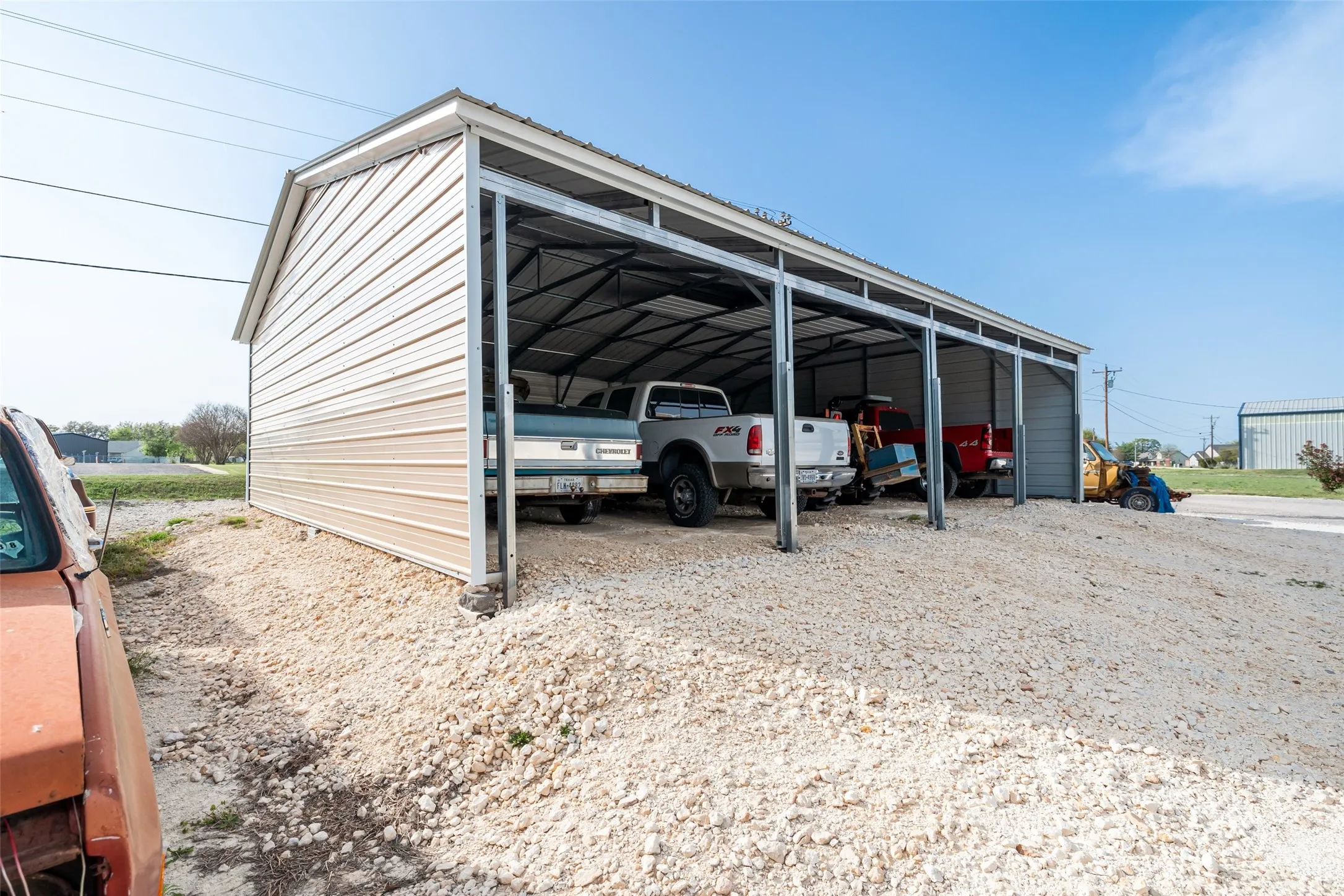 View of parking with driveway and a carport
