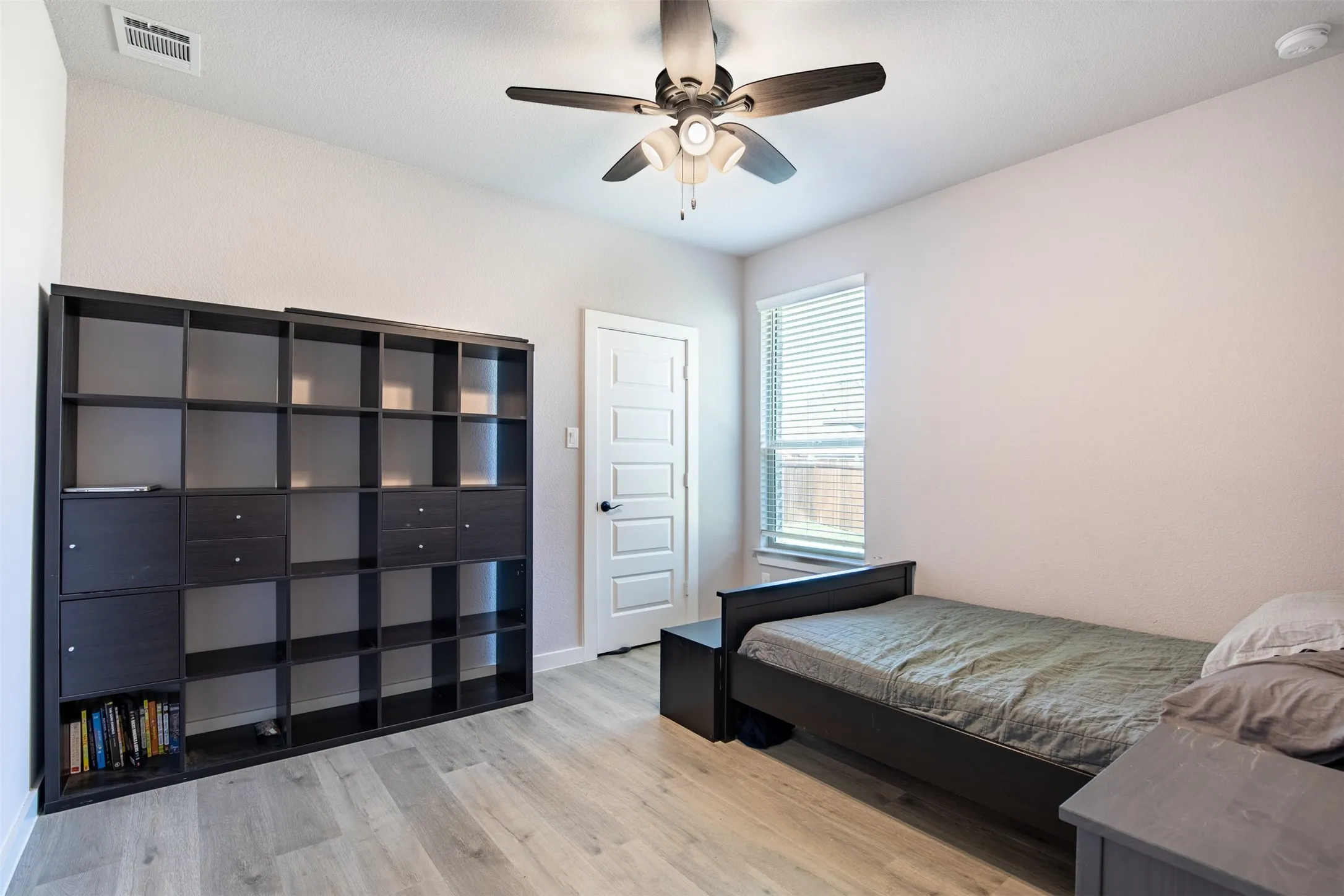 Secondary bedroom with ceiling fan and walk-in closet.