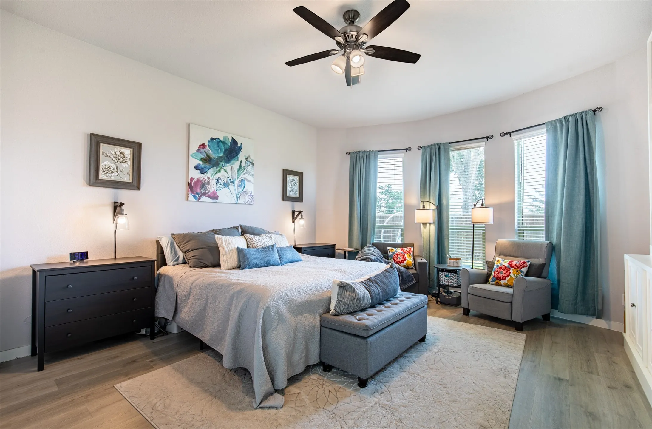 Primary suite with wall of windows overlooking the backyard.