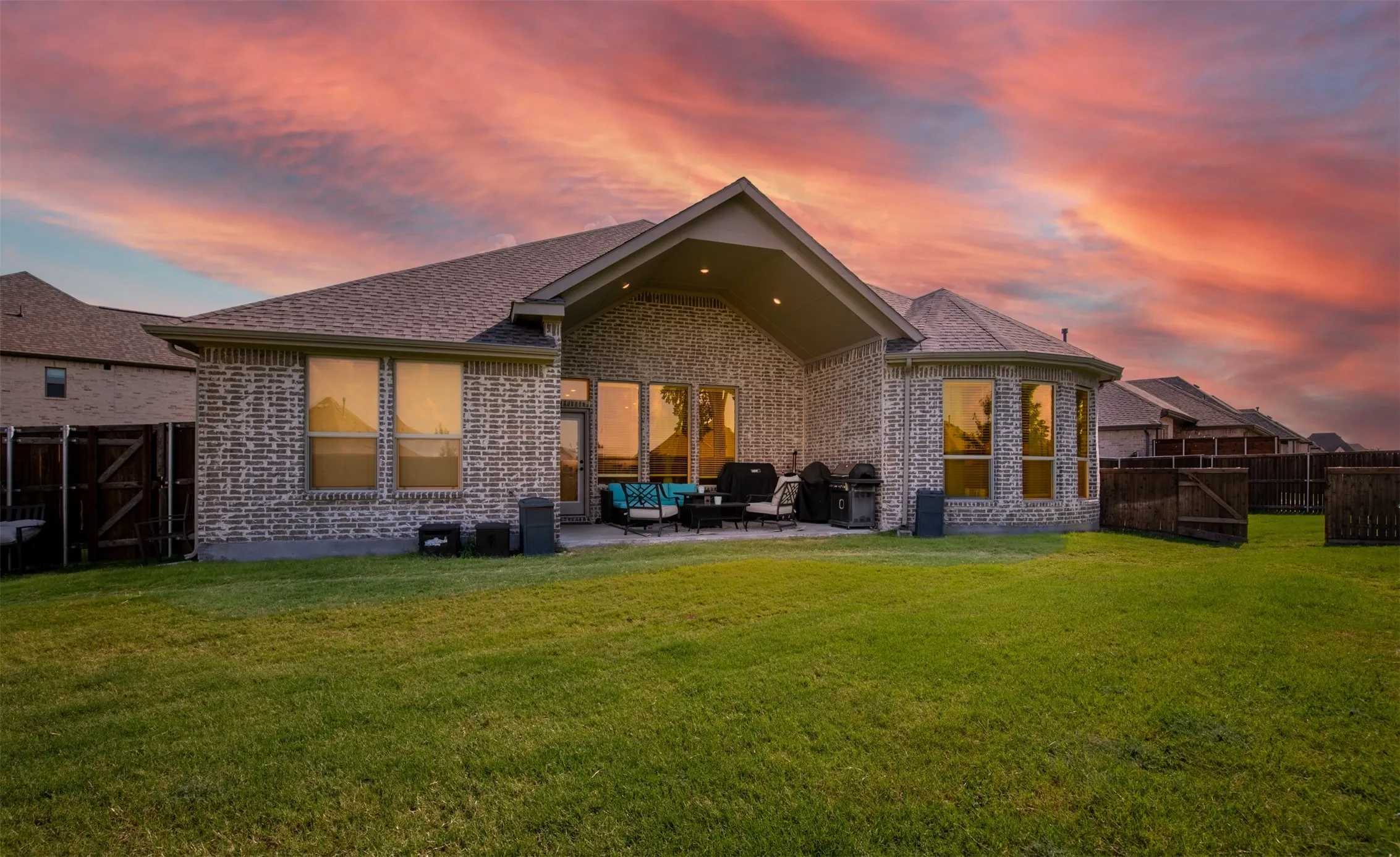 Covered patio with large grassy backyard.