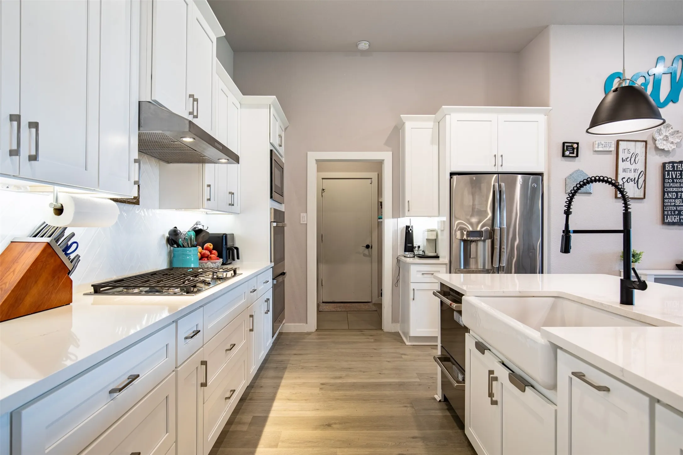 Kitchen features under-cabinet lighting and double wall ovens.