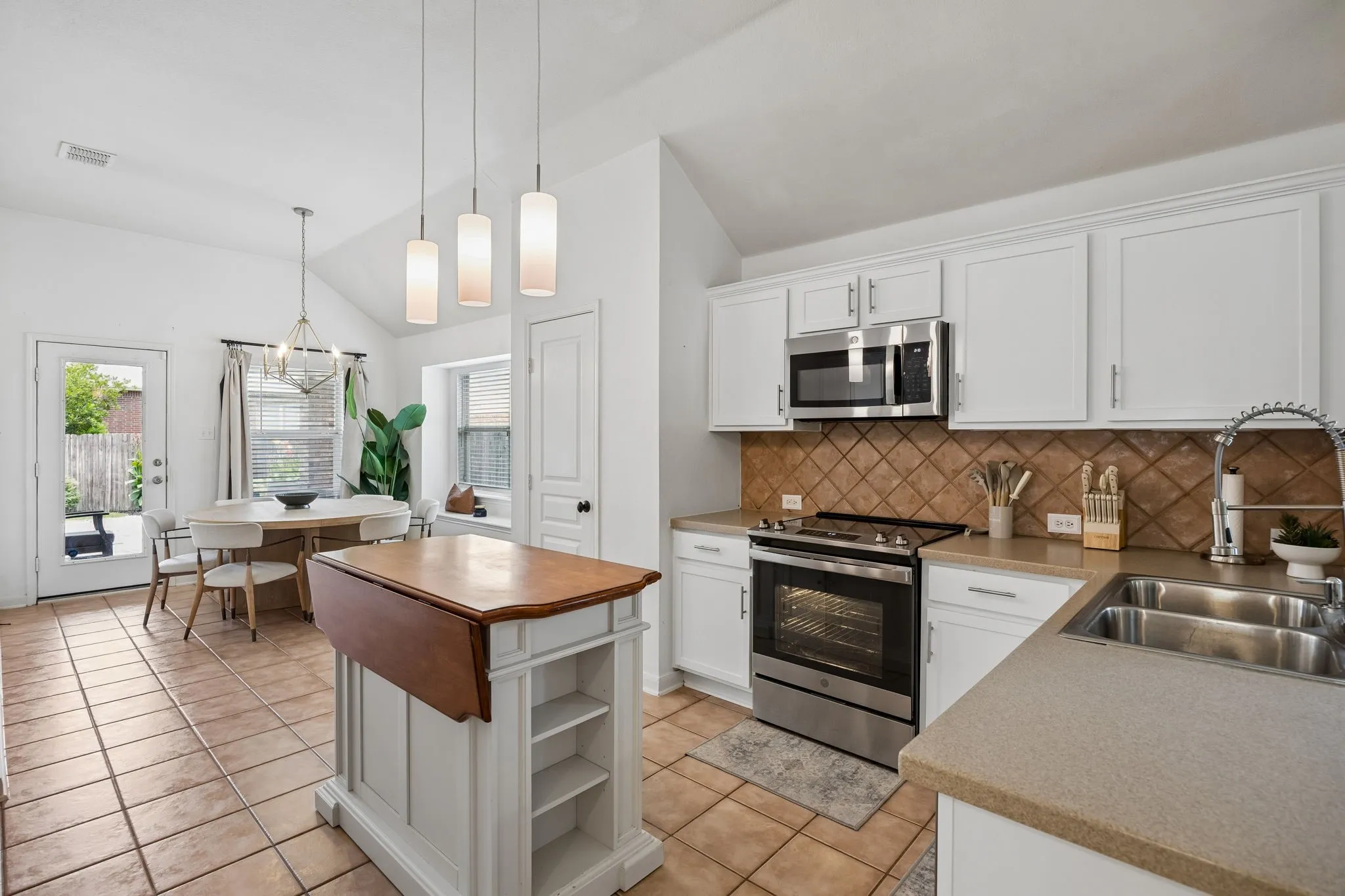 The kitchen is equipped with a stainless steel sink, built-in microwave and electric range.