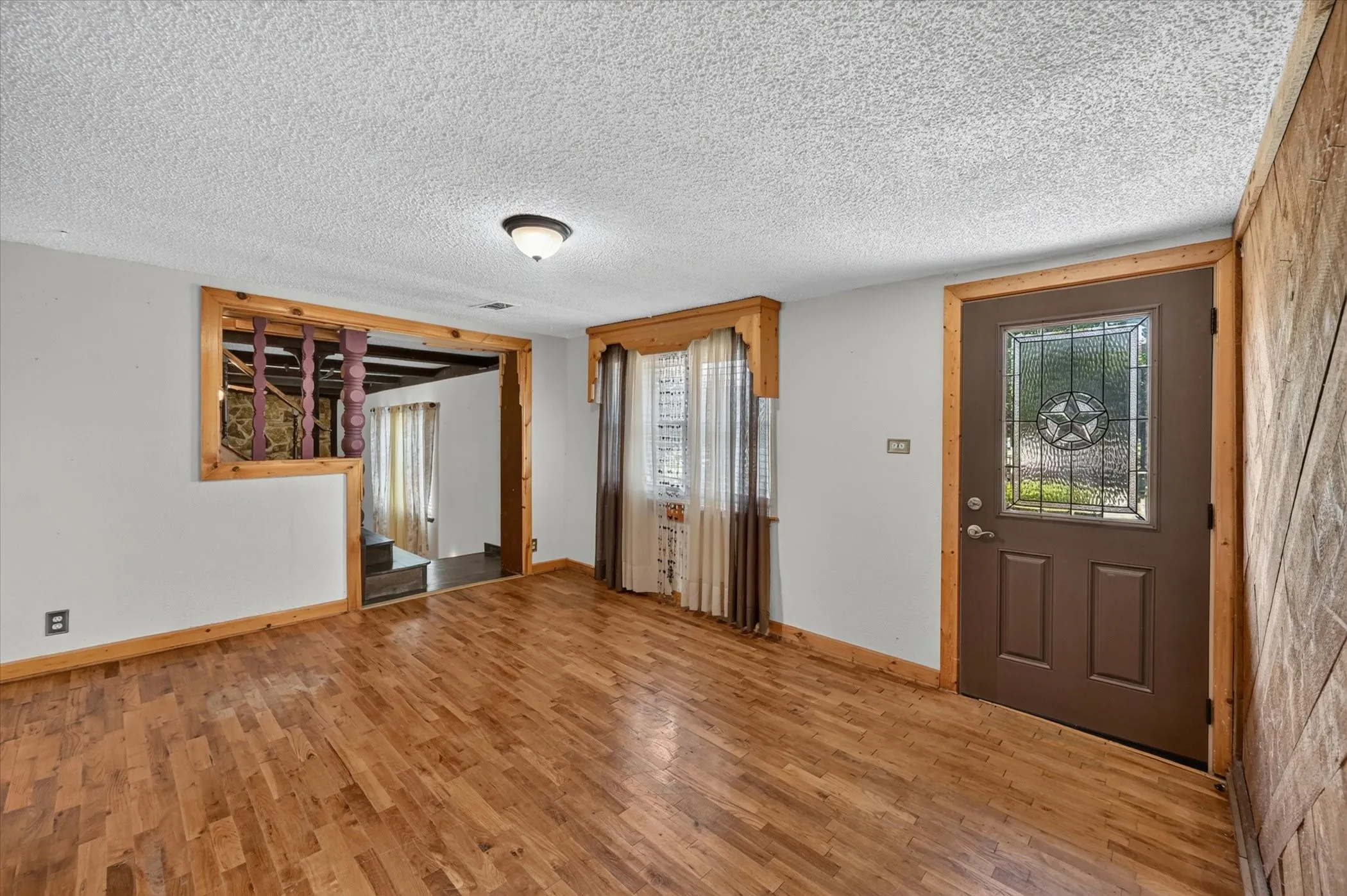 Entryway featuring wood-finish flooring and a decorative front door with a stained glass insert