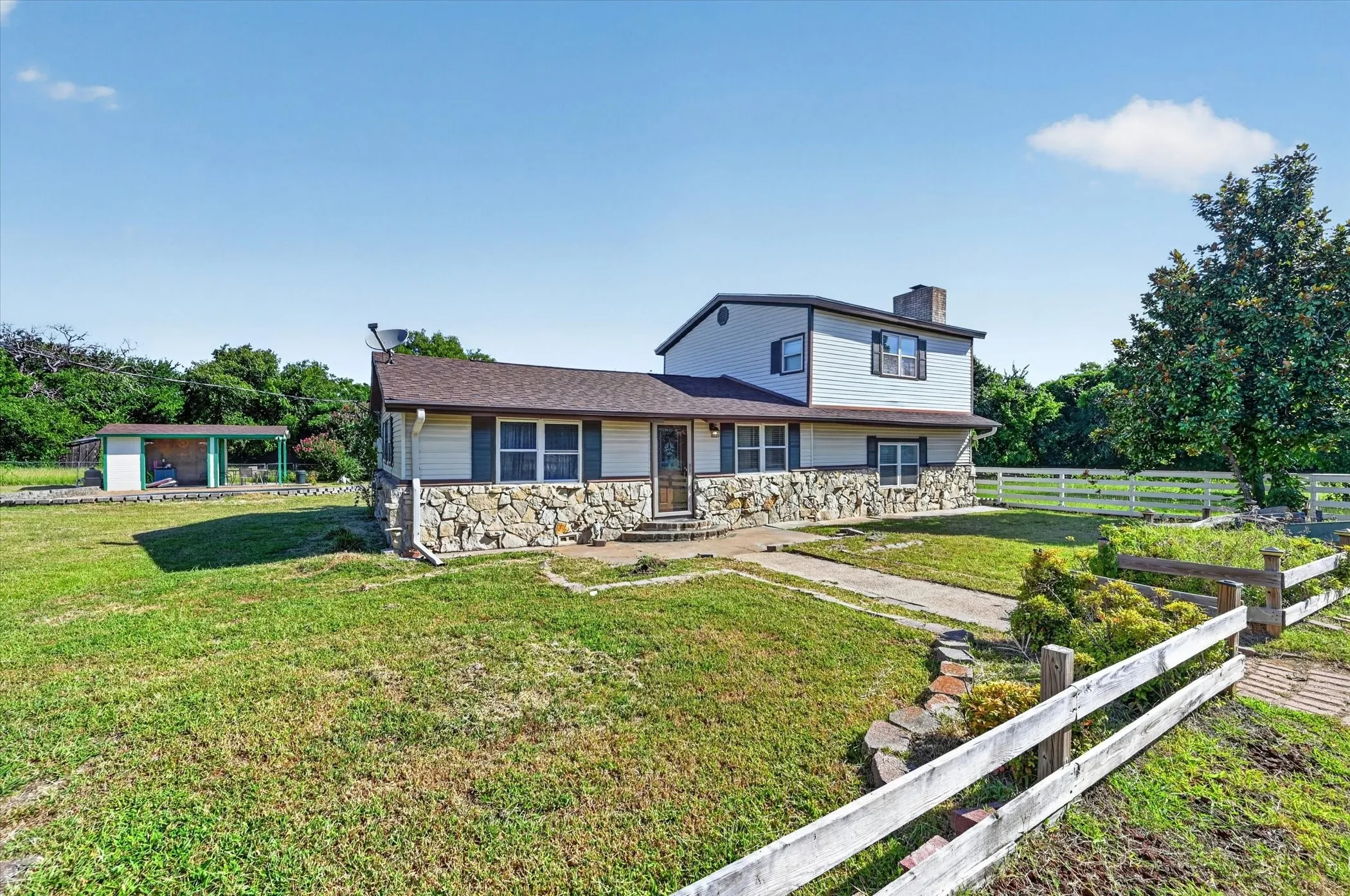 Split-level residence featuring stone veneer and horizontal siding