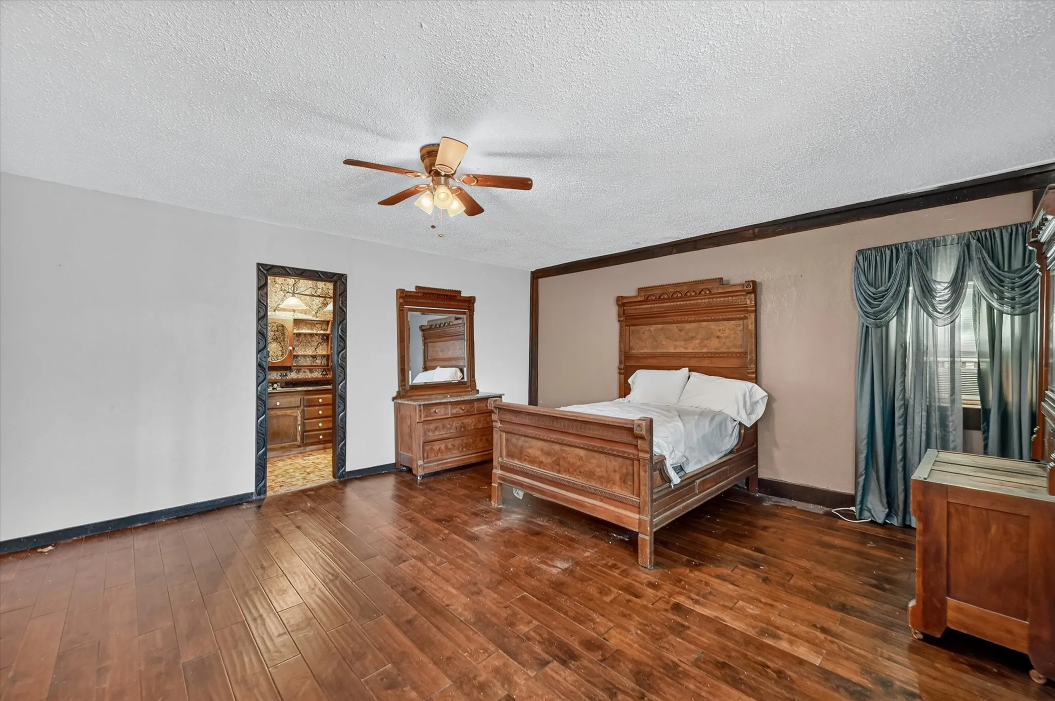 Spacious room featuring wood-finish flooring and a ceiling fan with integrated lighting