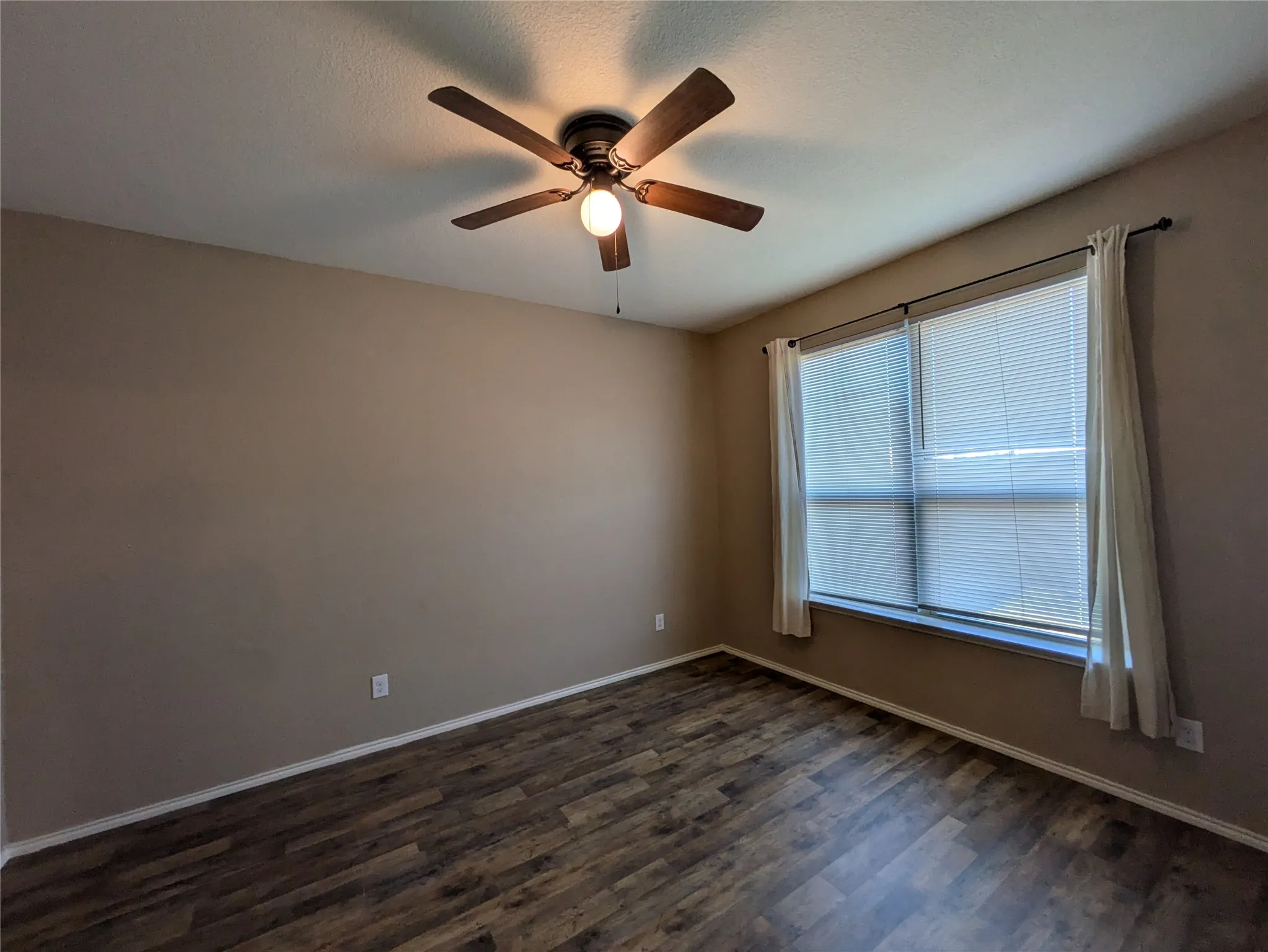 Unfurnished room featuring dark hardwood / wood-style flooring and ceiling fan