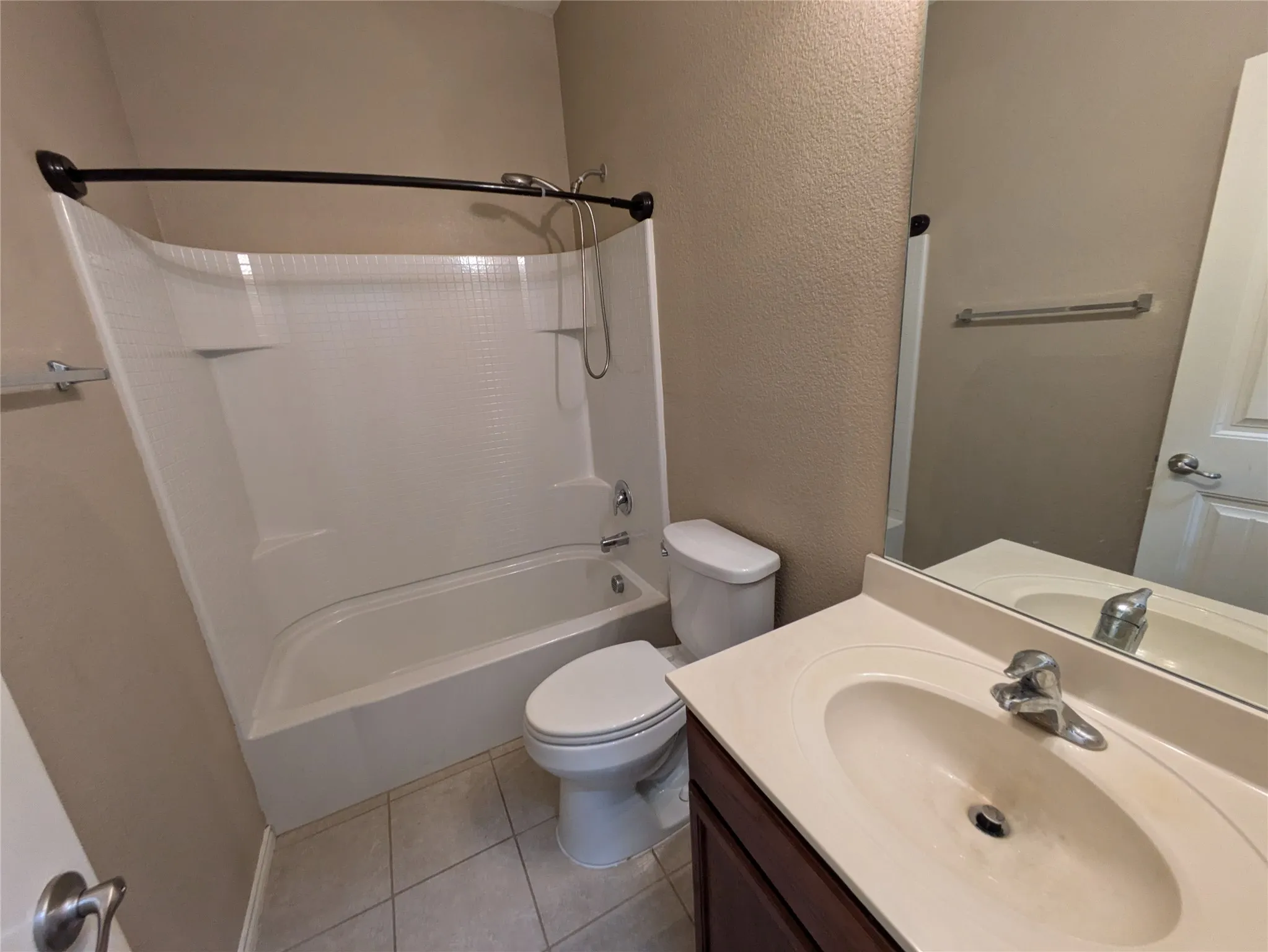 Full bathroom featuring washtub / shower combination, vanity, toilet, and tile patterned floors