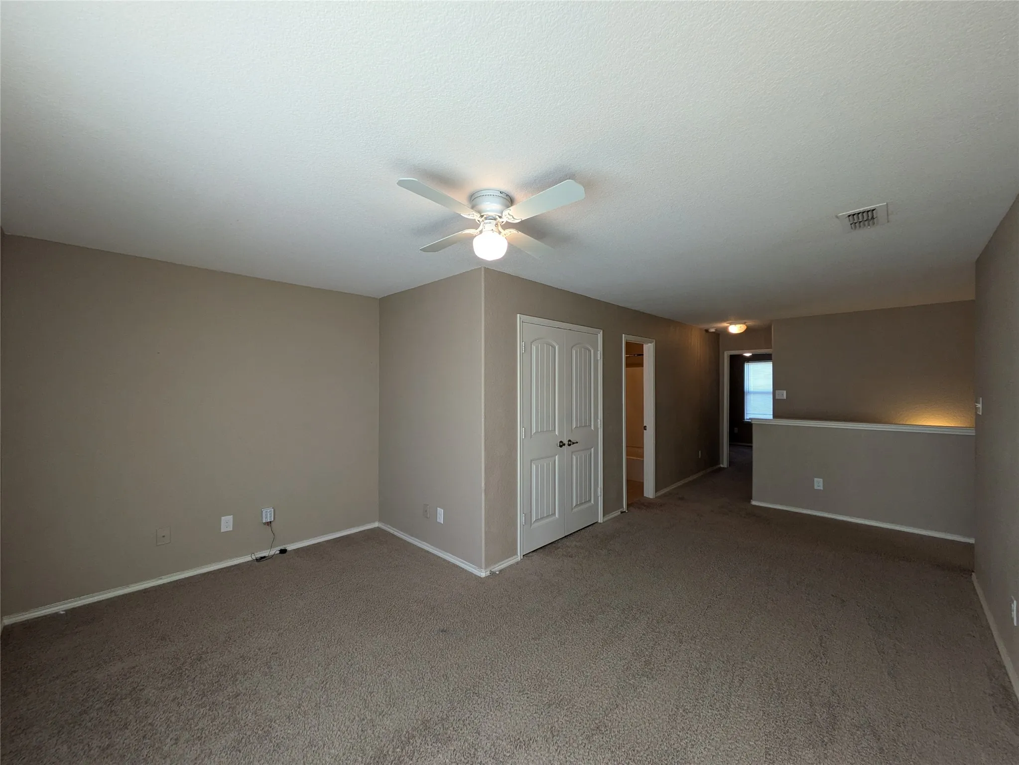 Unfurnished room featuring dark colored carpet and ceiling fan