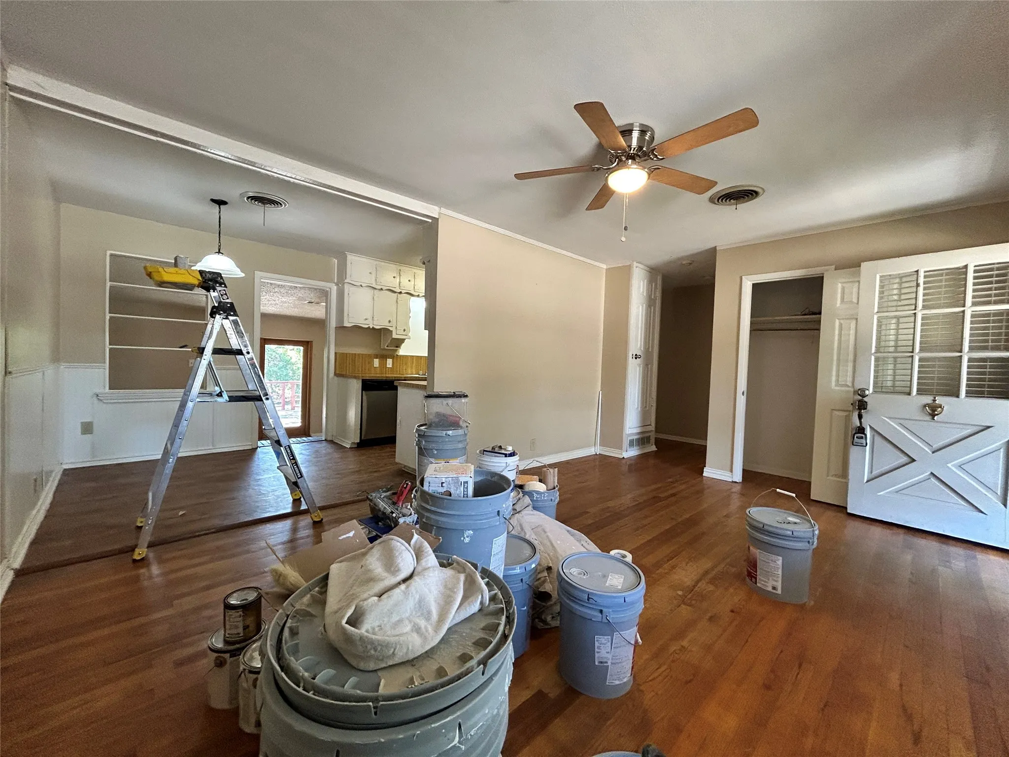 Wood-finish flooring throughout, ceiling fan with light fixture, built-in shelving, and a double-door closet