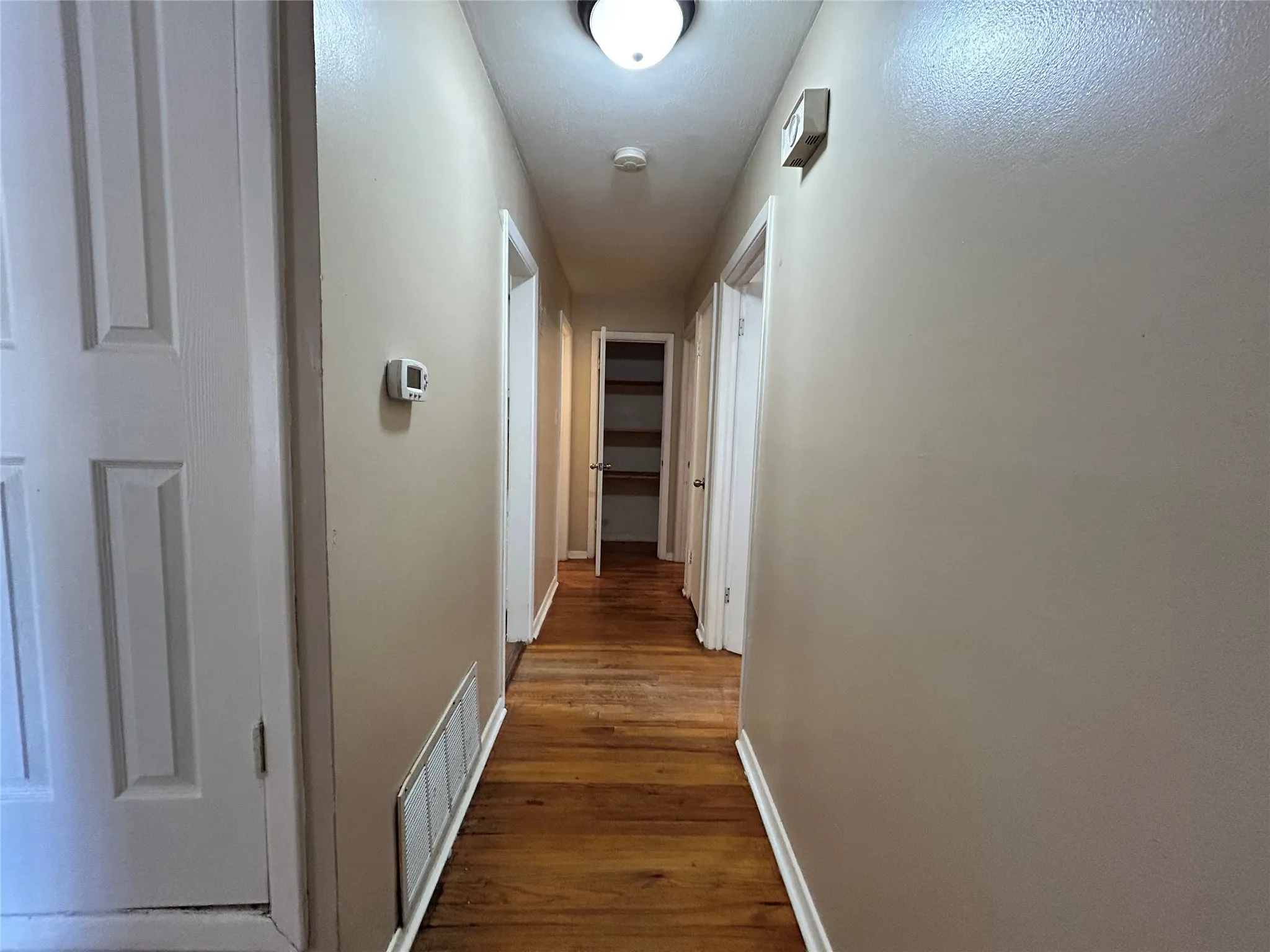 Hardwood flooring throughout, neutral wall tones, interior panel doors, and recessed ceiling light fixture