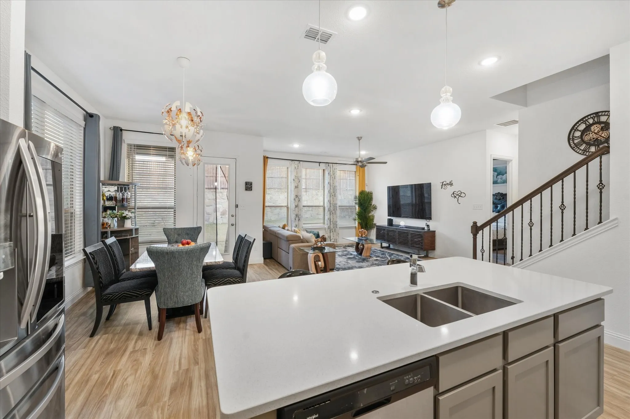 Kitchen island with an undermount double-basin sink, light-toned countertop, and integrated dishwasher
