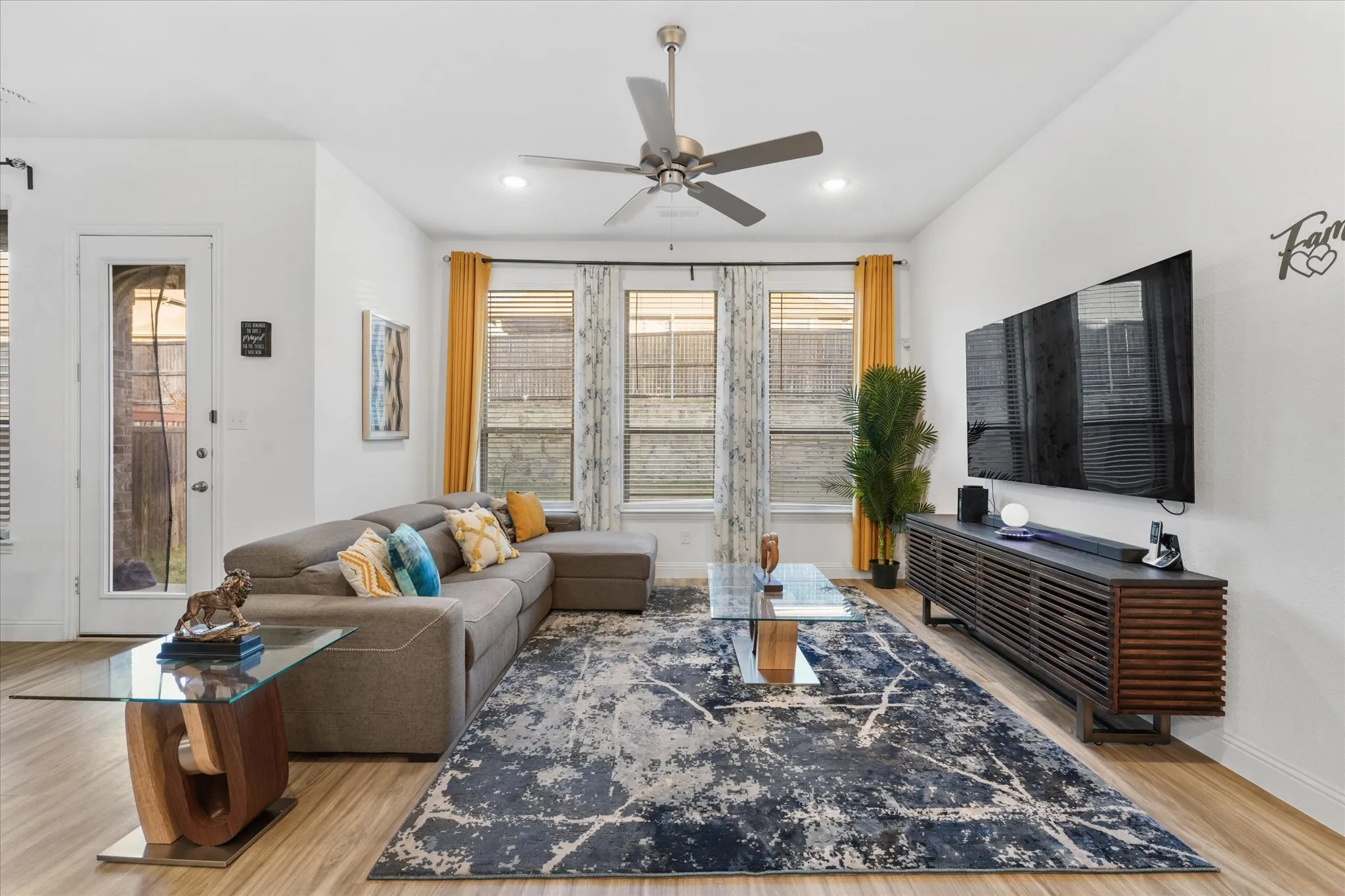 Open-concept living space featuring wood-finish flooring, recessed lighting, and a ceiling fan