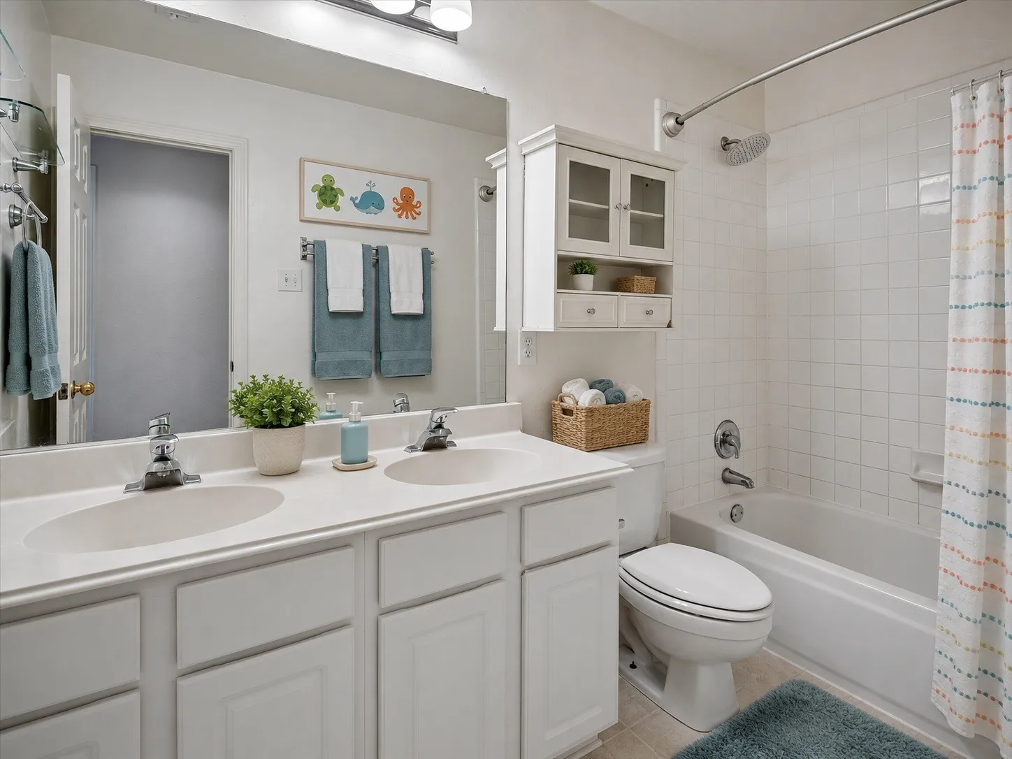 Upstairs secondary bathroom has dual sinks, cabinets, elongated toilet, c-tile flooring and tub-shower combo.