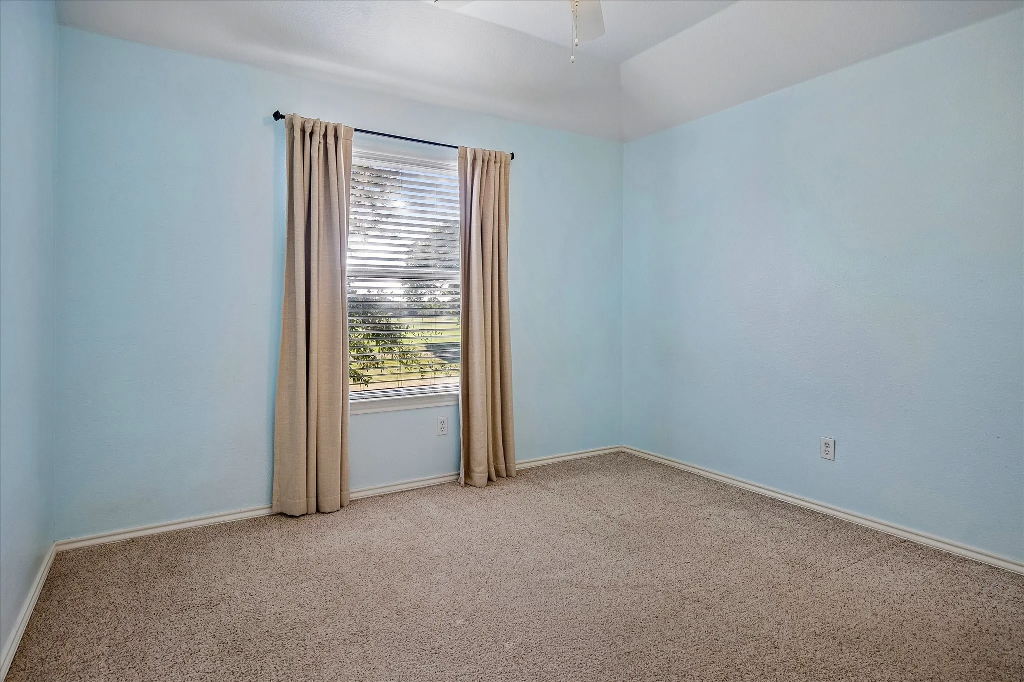 Secondary bedroom overlooks the golf course, has a ceiling fan, customized closet, 2in faux wood blinds and carpet.