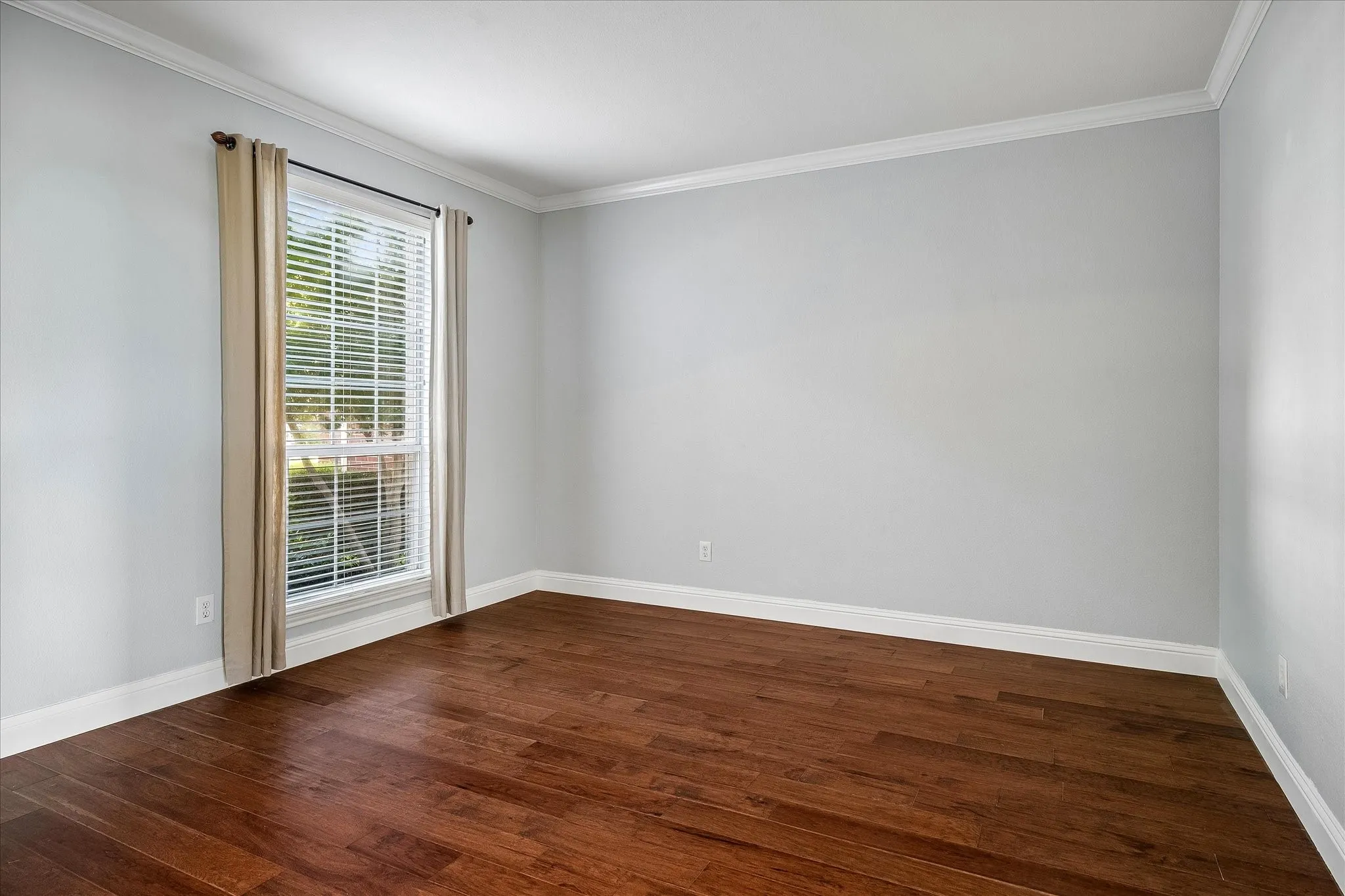 Flexible Living Area with engineered hardwood flooring, 2in faux wood blinds, and crown molding.