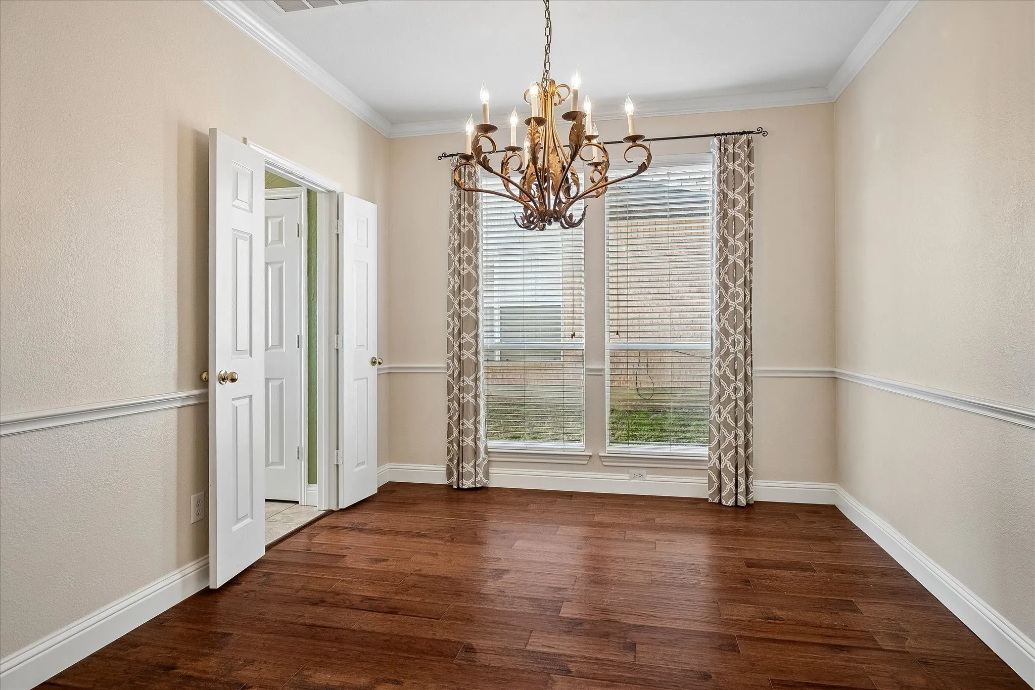Formal dining room is tucked for privacy but gives you easy access to kitchen.  Boasts engineered hardwood flooring, decorative light, chair railing, crown molding, and 2in faux wood blinds.