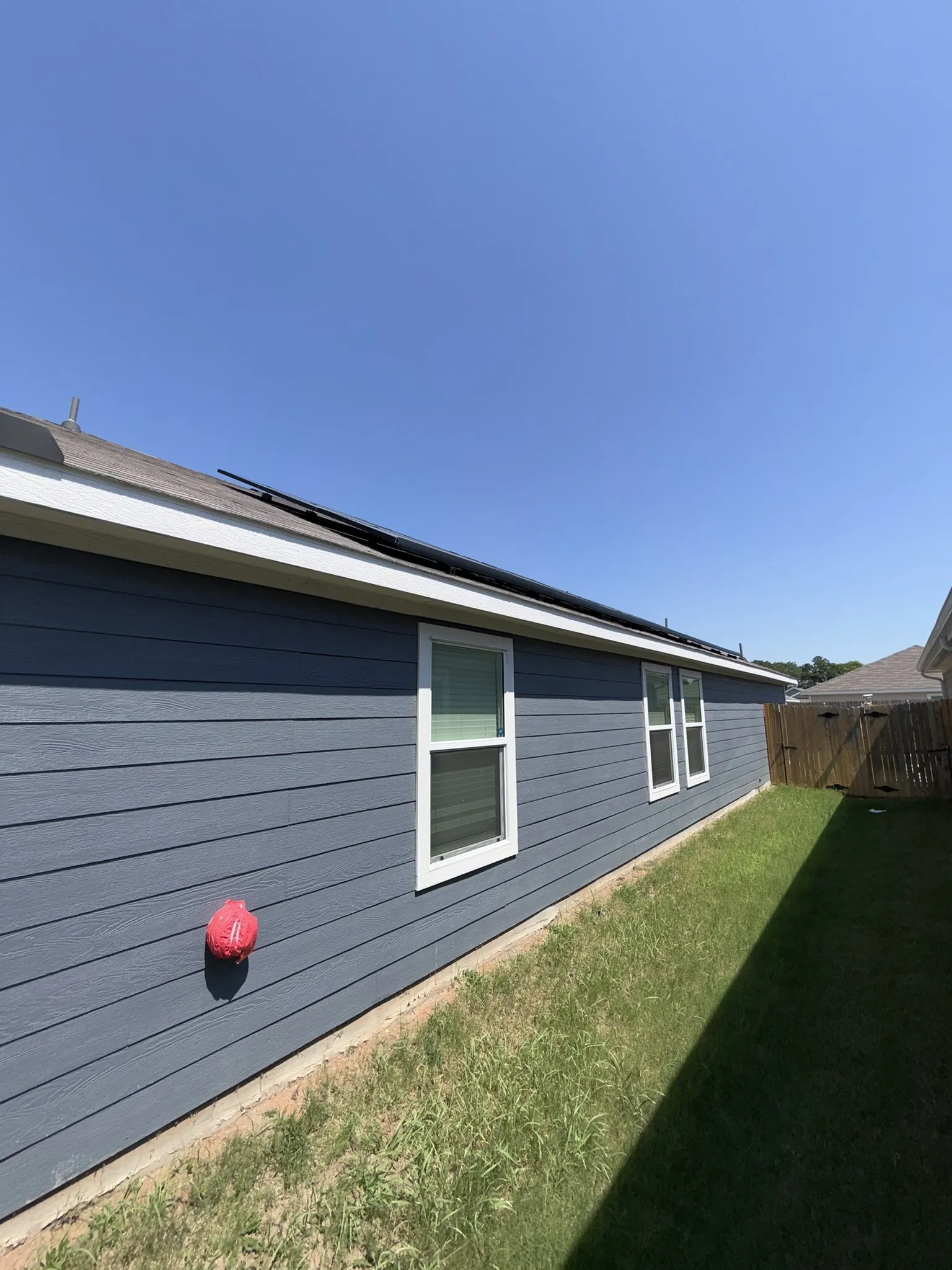 Exterior featuring blue horizontal siding, white trim, and multiple windows