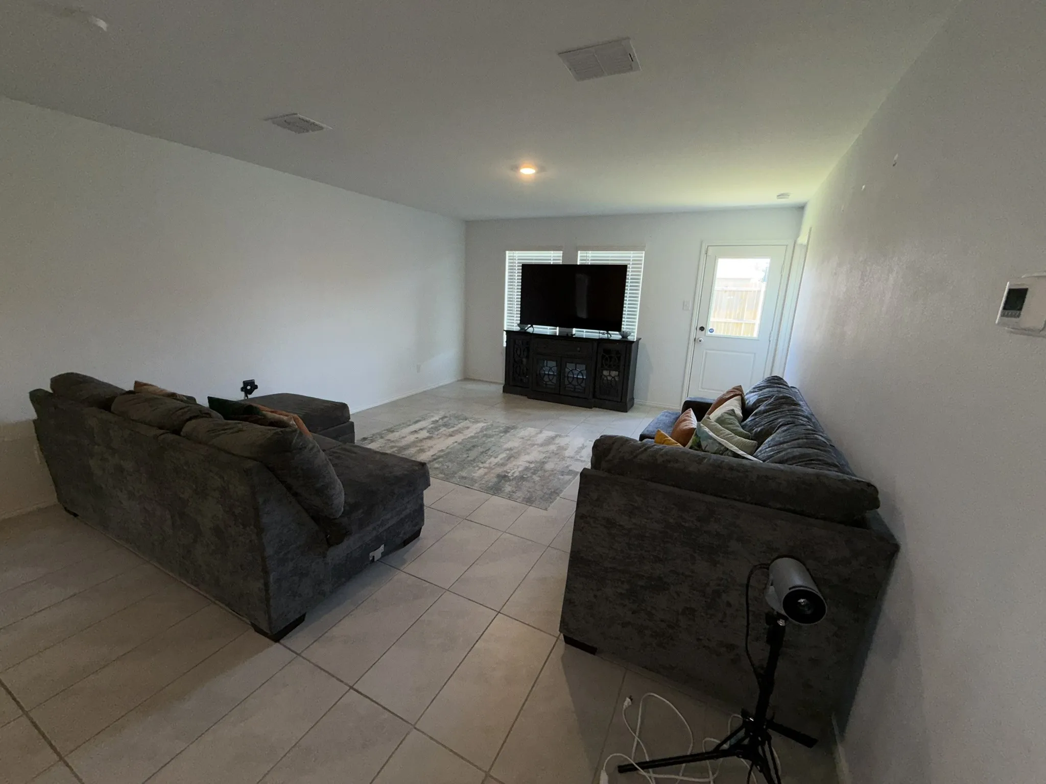Spacious room featuring neutral-toned walls, recessed lighting, and tile flooring