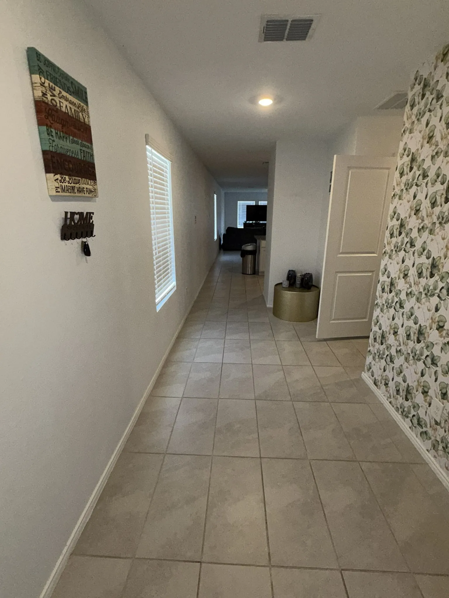 Hallway featuring tile flooring, white baseboards, and recessed lighting