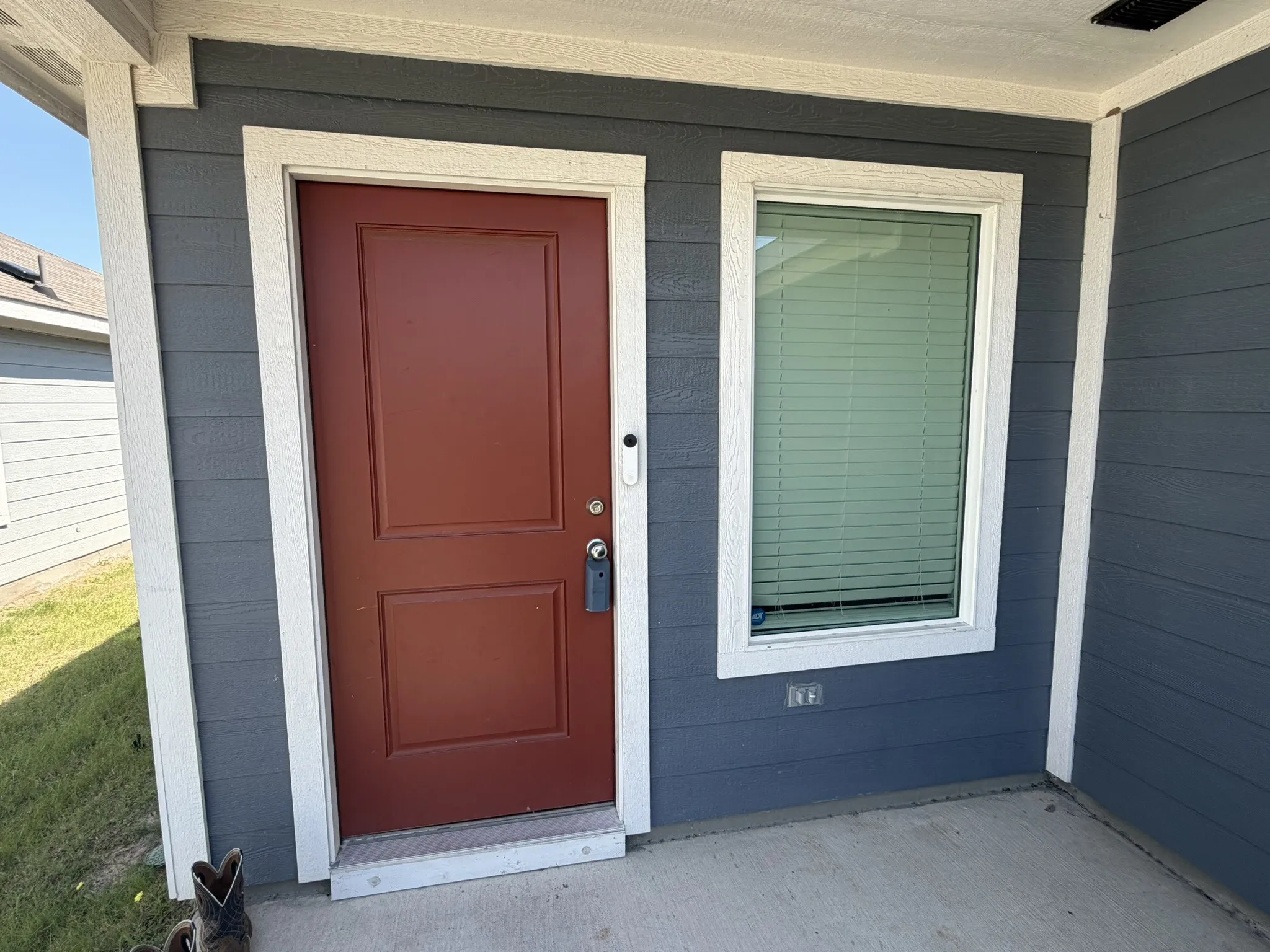 Exterior entry featuring a paneled door with hardware, a window with horizontal blinds, and horizontal siding