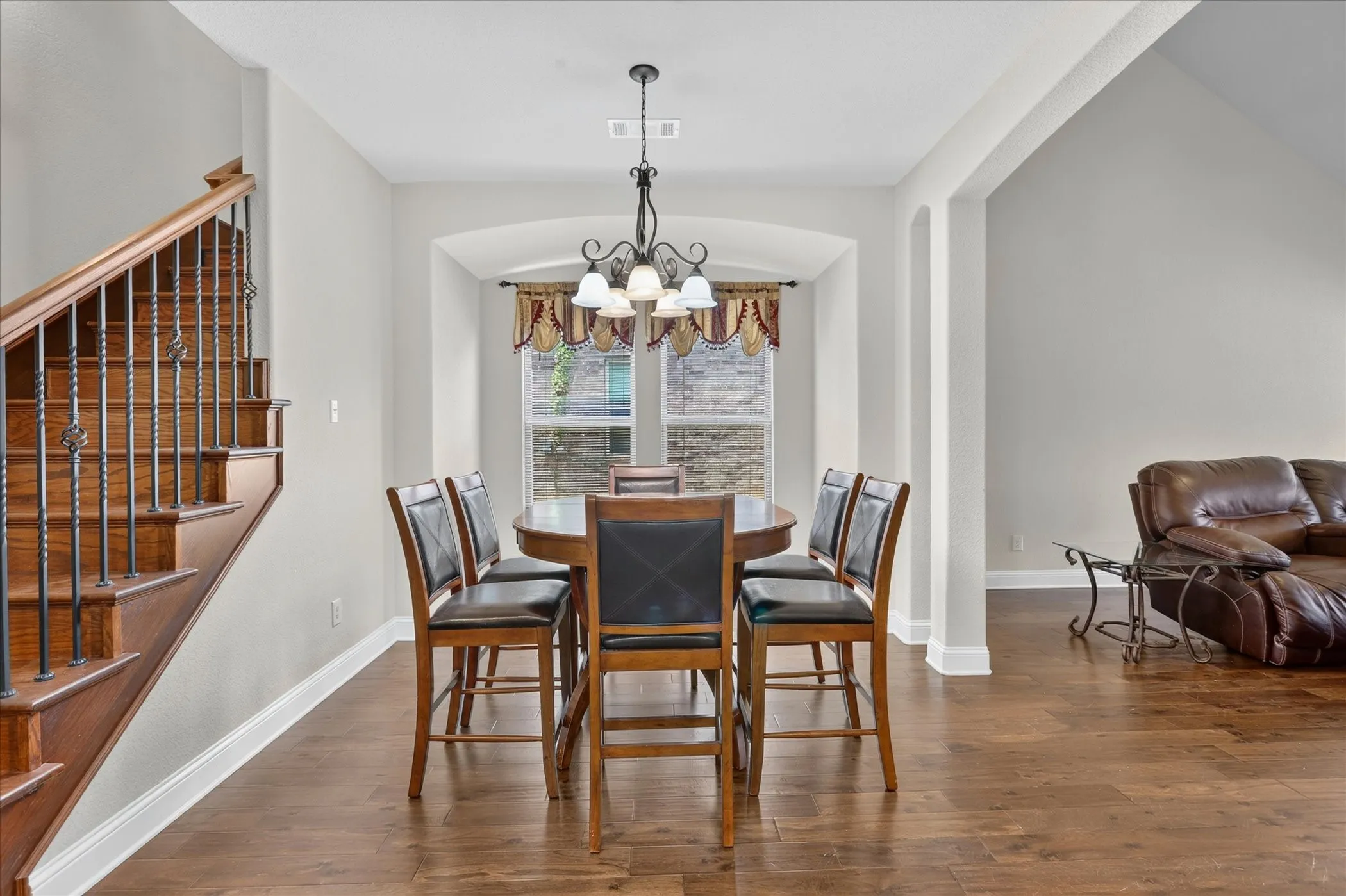 Dining area with wood-finish flooring and a central chandelier