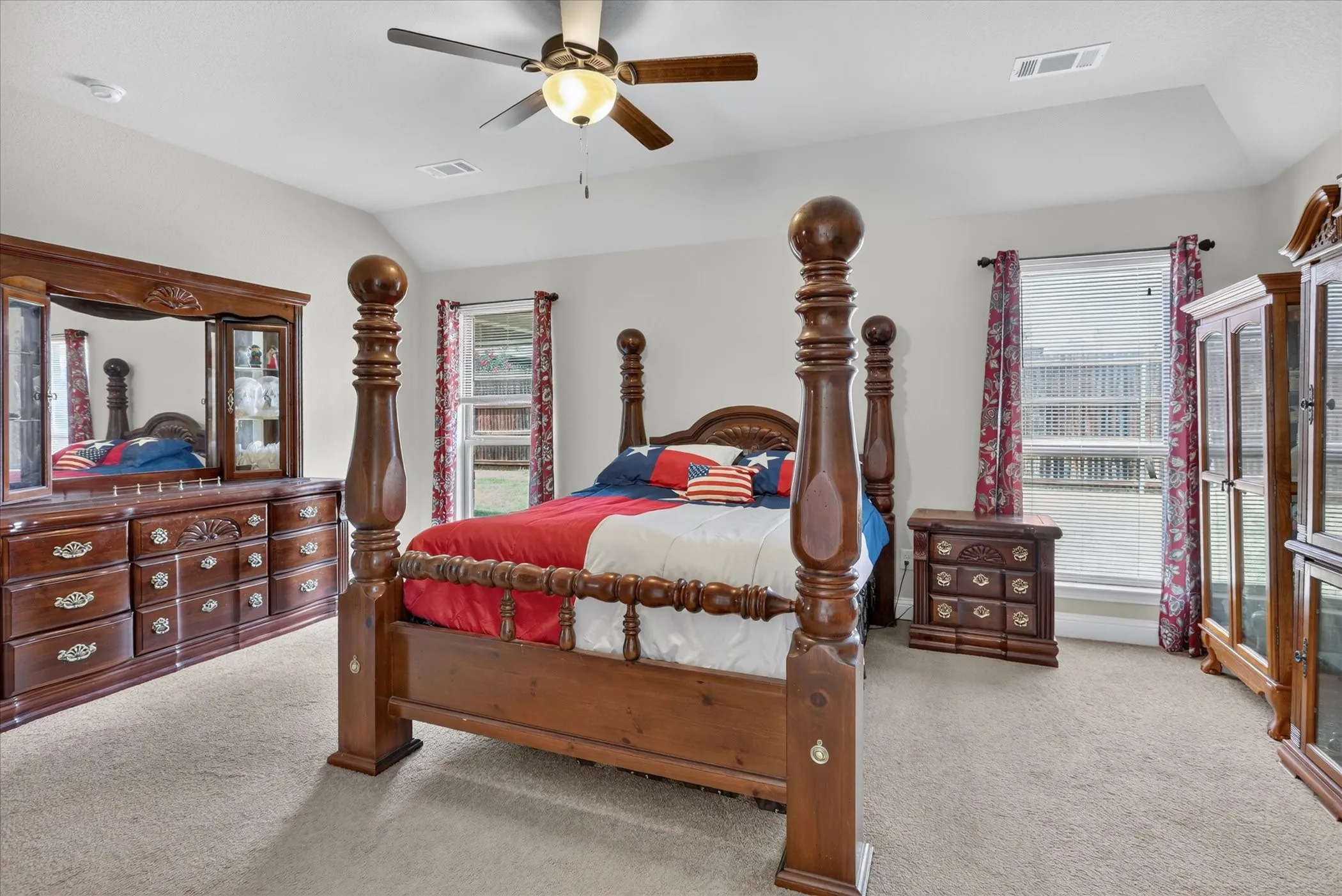 Carpeted room featuring a ceiling fan with integrated lighting, a tray ceiling, and dual windows with​​‌​​​​‌​​‌‌​‌‌​​​‌‌​‌​‌​‌​​​‌​​ blinds