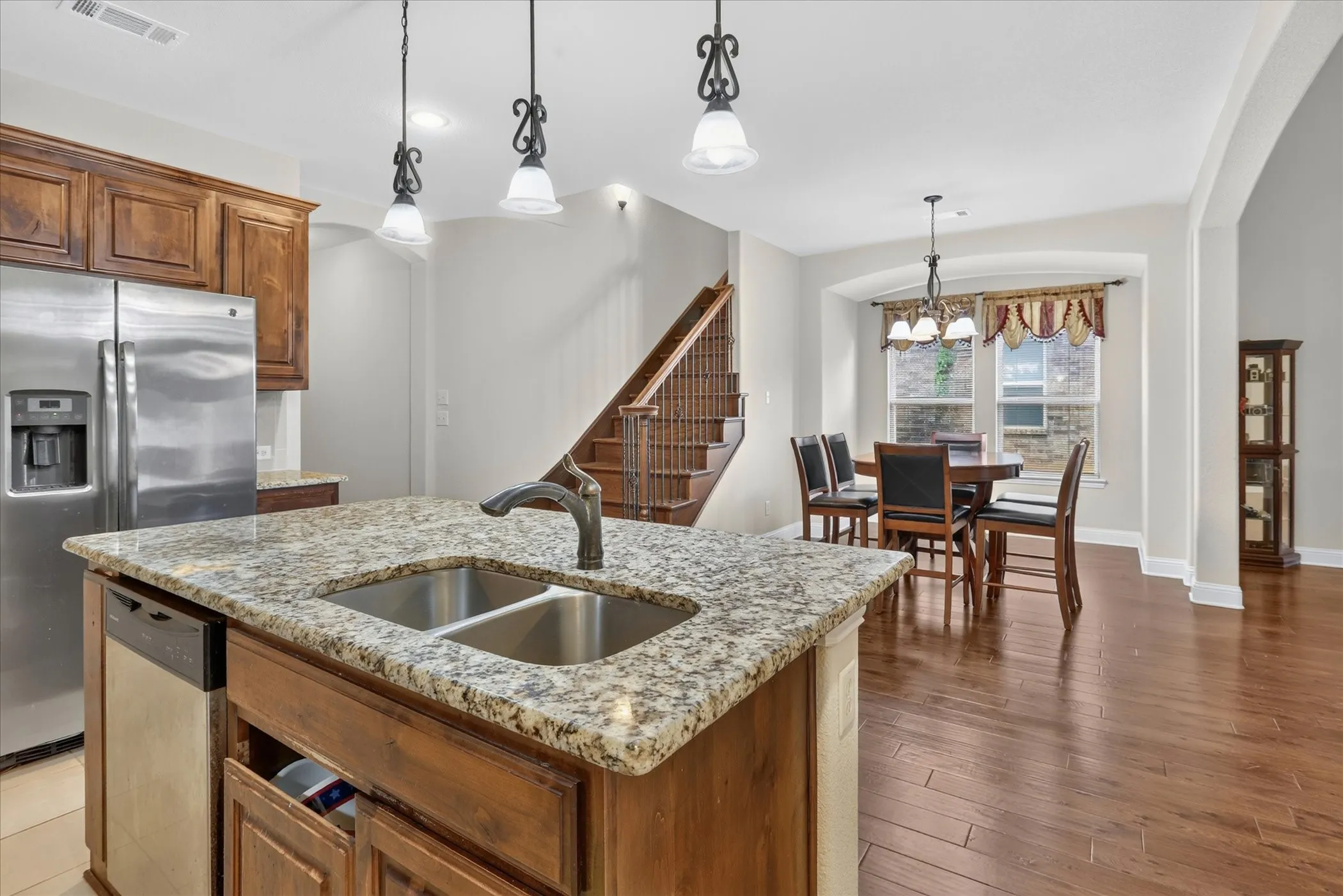 Kitchen island featuring a double-basin stainless steel sink and granite countertop