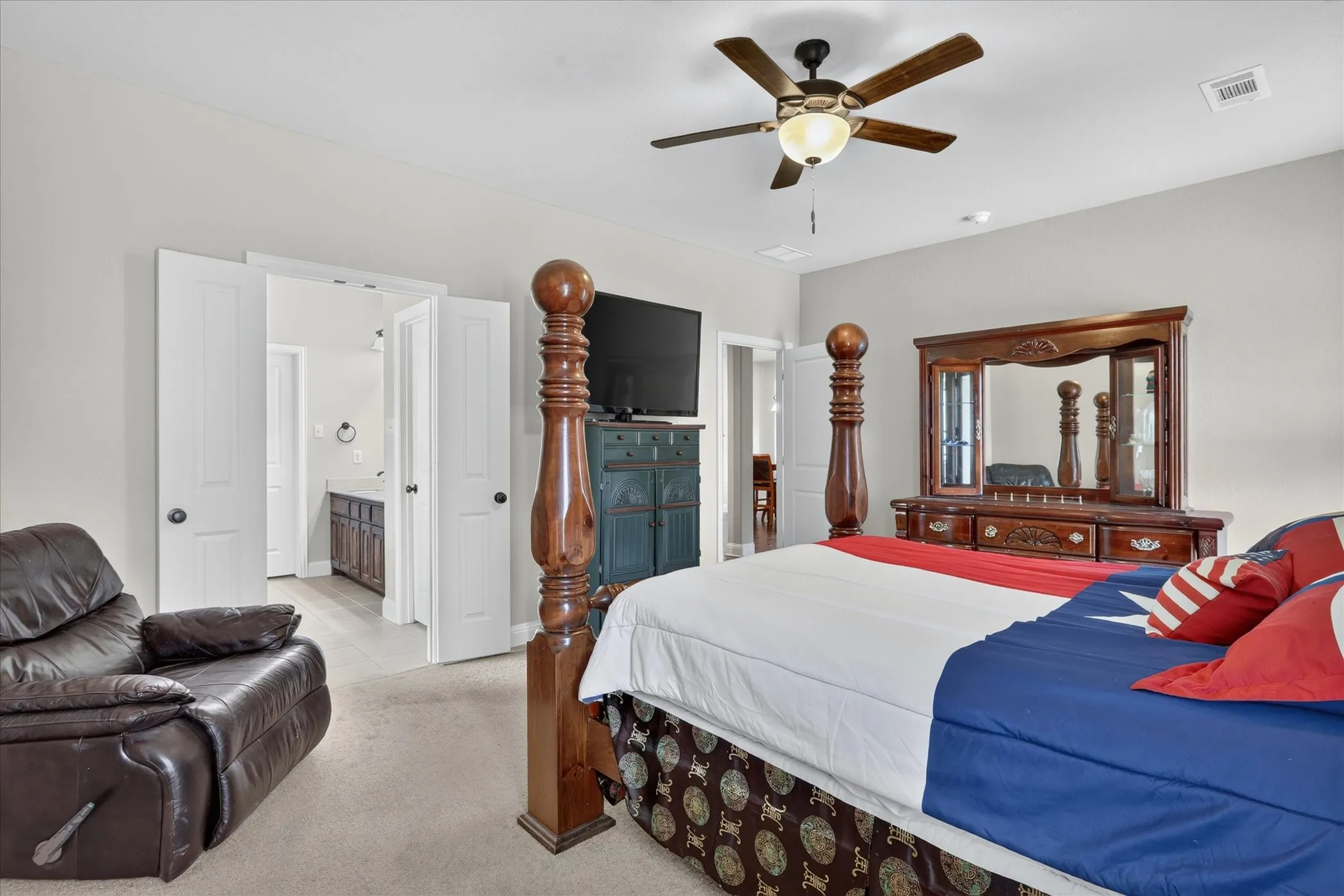 Carpeted bedroom with a ceiling fan light fixture and recessed lighting