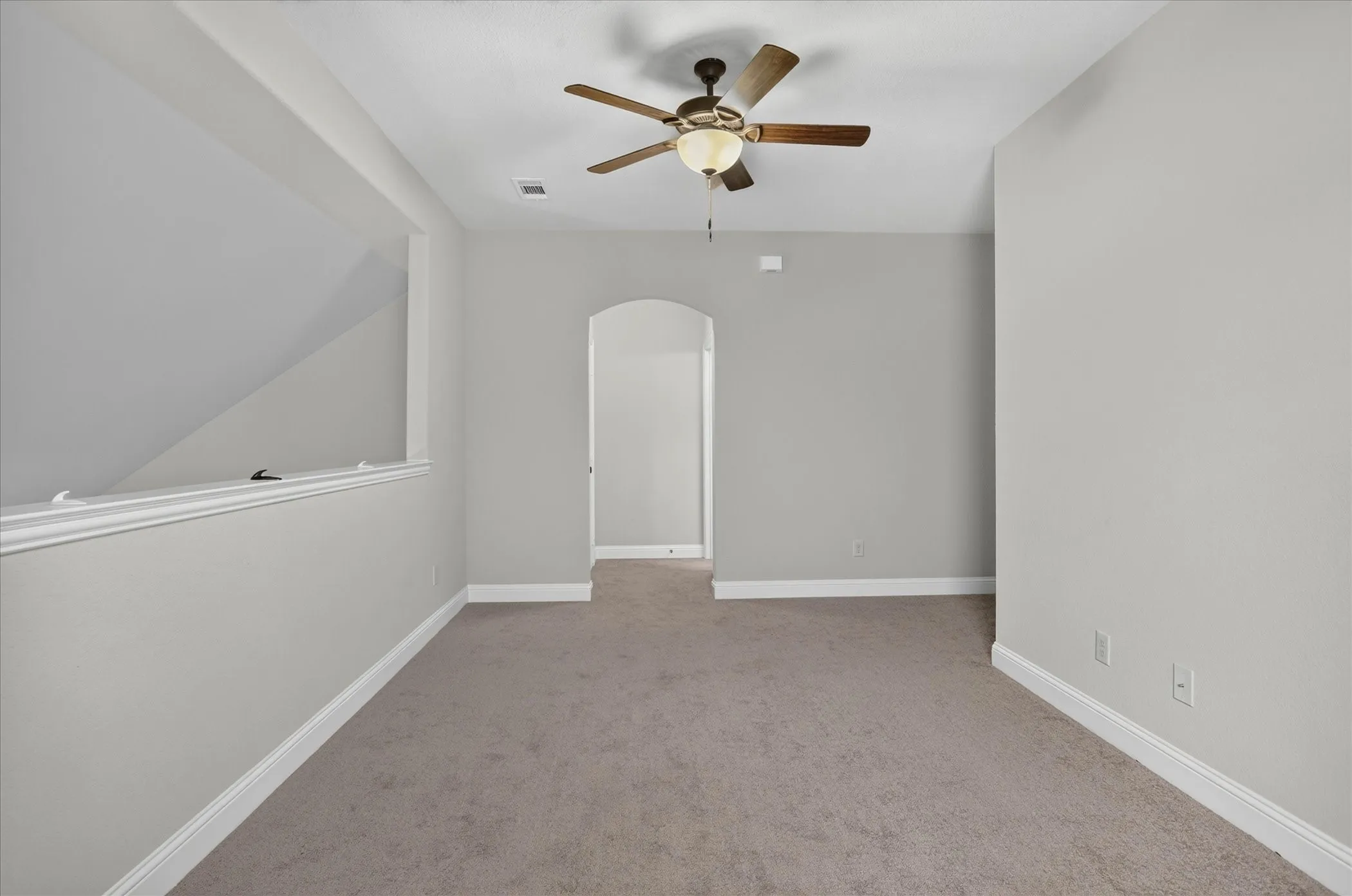 Spacious room featuring neutral carpeting and light-toned walls