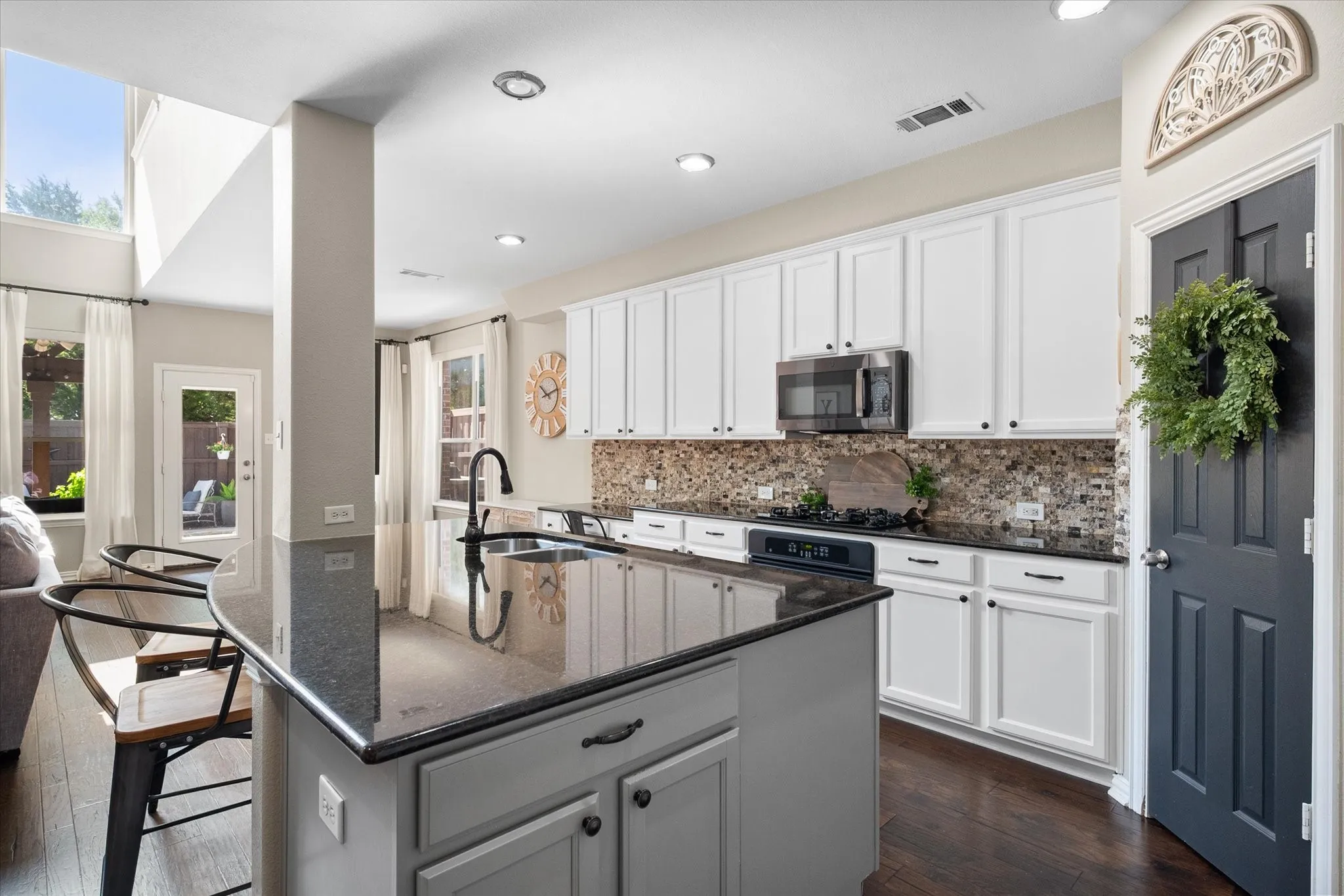 Spacious breakfast nook, glass-paneled exterior door, and a geometric pendant light fixture overlooking the backyard!
