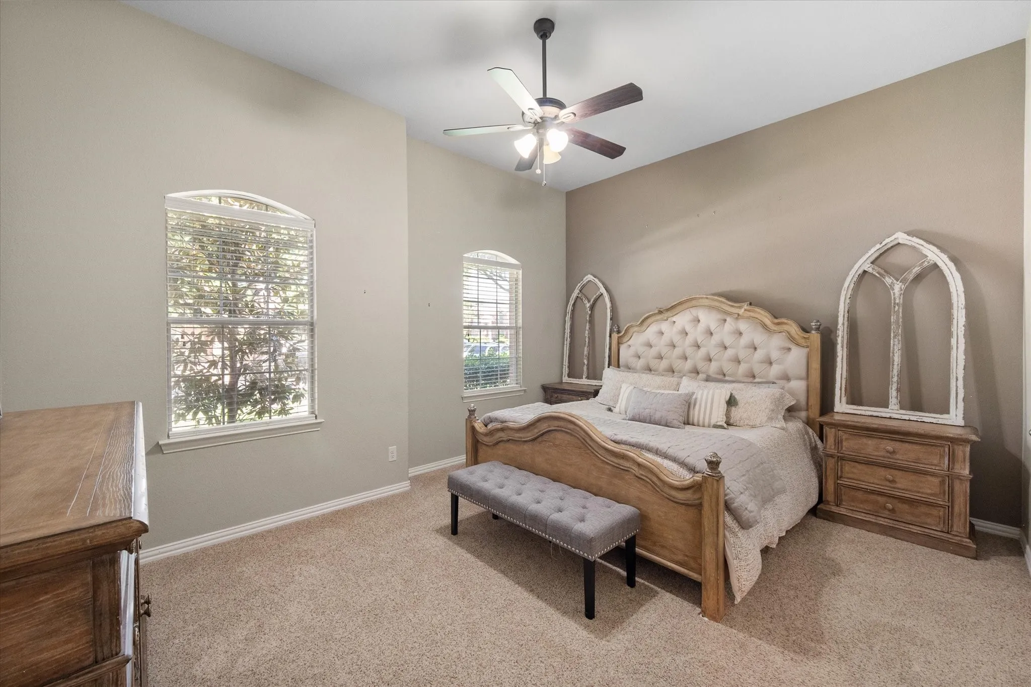 Private primary suite featuring ceiling fans and arched windows!