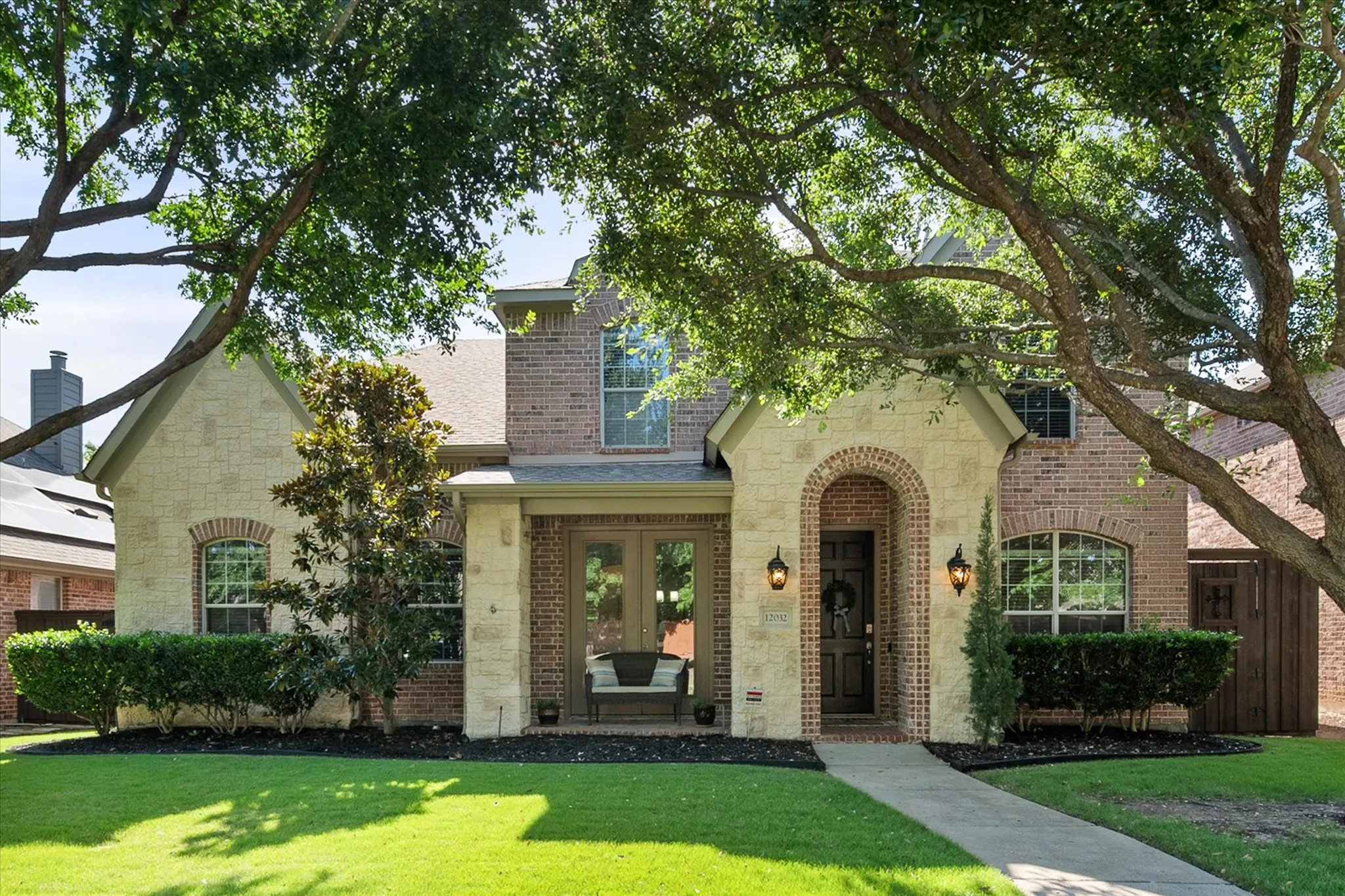 Beautiful Stone facade with arched entryway along with French doors and a covered porch!