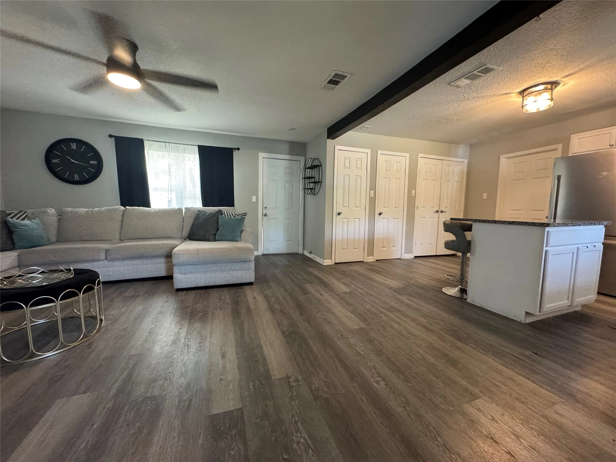 Open-concept living space with wood-finish flooring, a contemporary ceiling fan, and recessed lighting