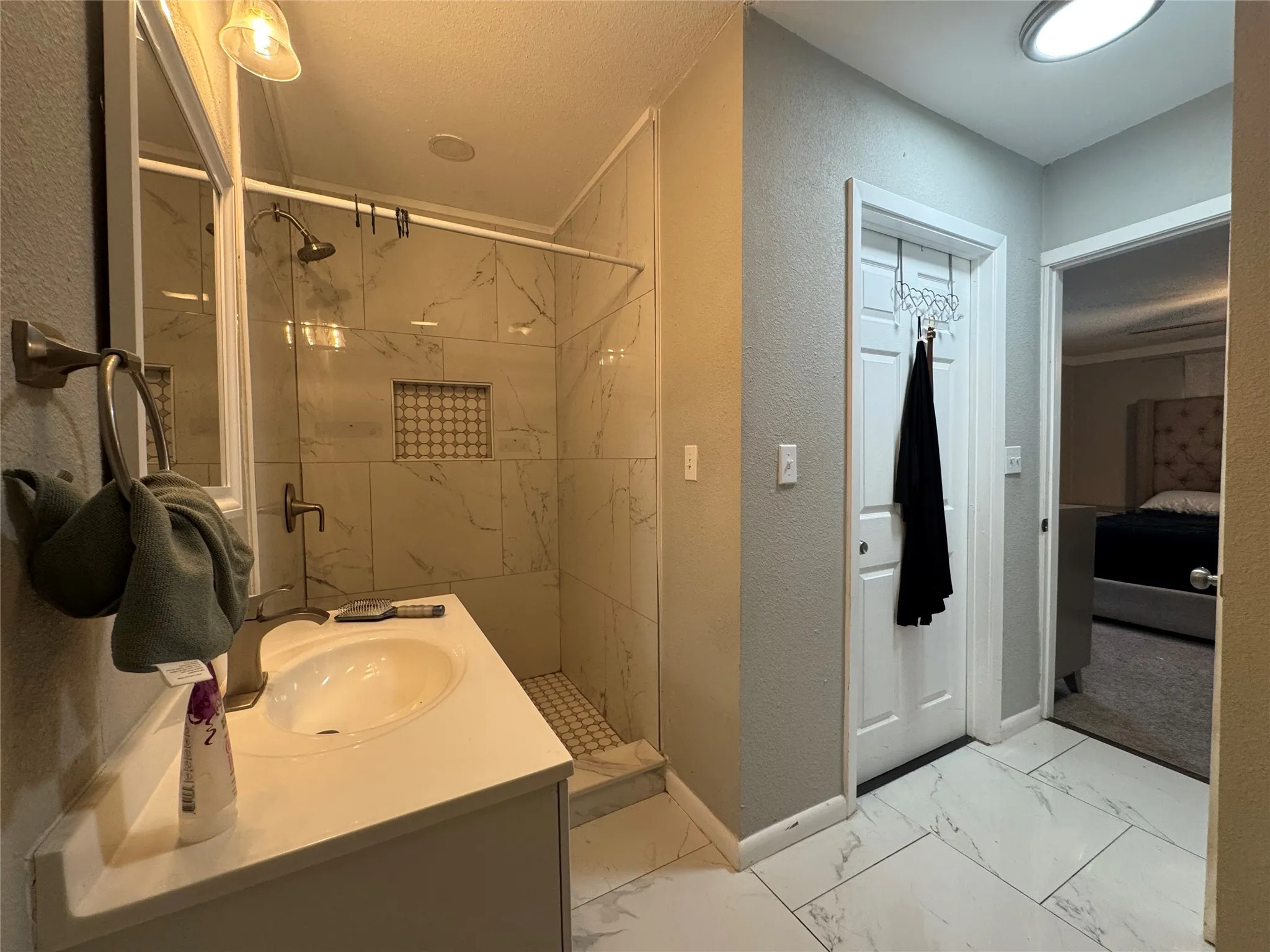Contemporary bathroom featuring a walk-in shower with clear glass enclosure and contrasting tile accent niche