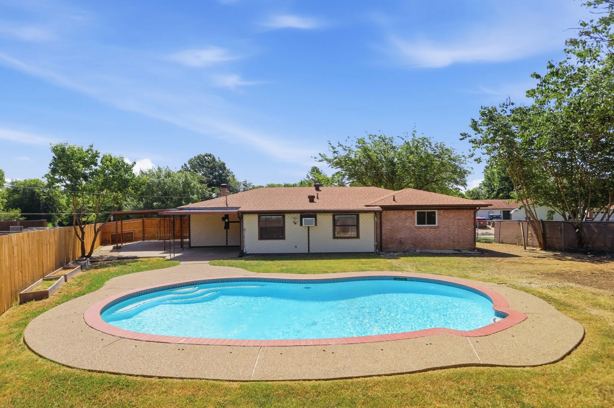 In-ground swimming pool with surrounding concrete decking