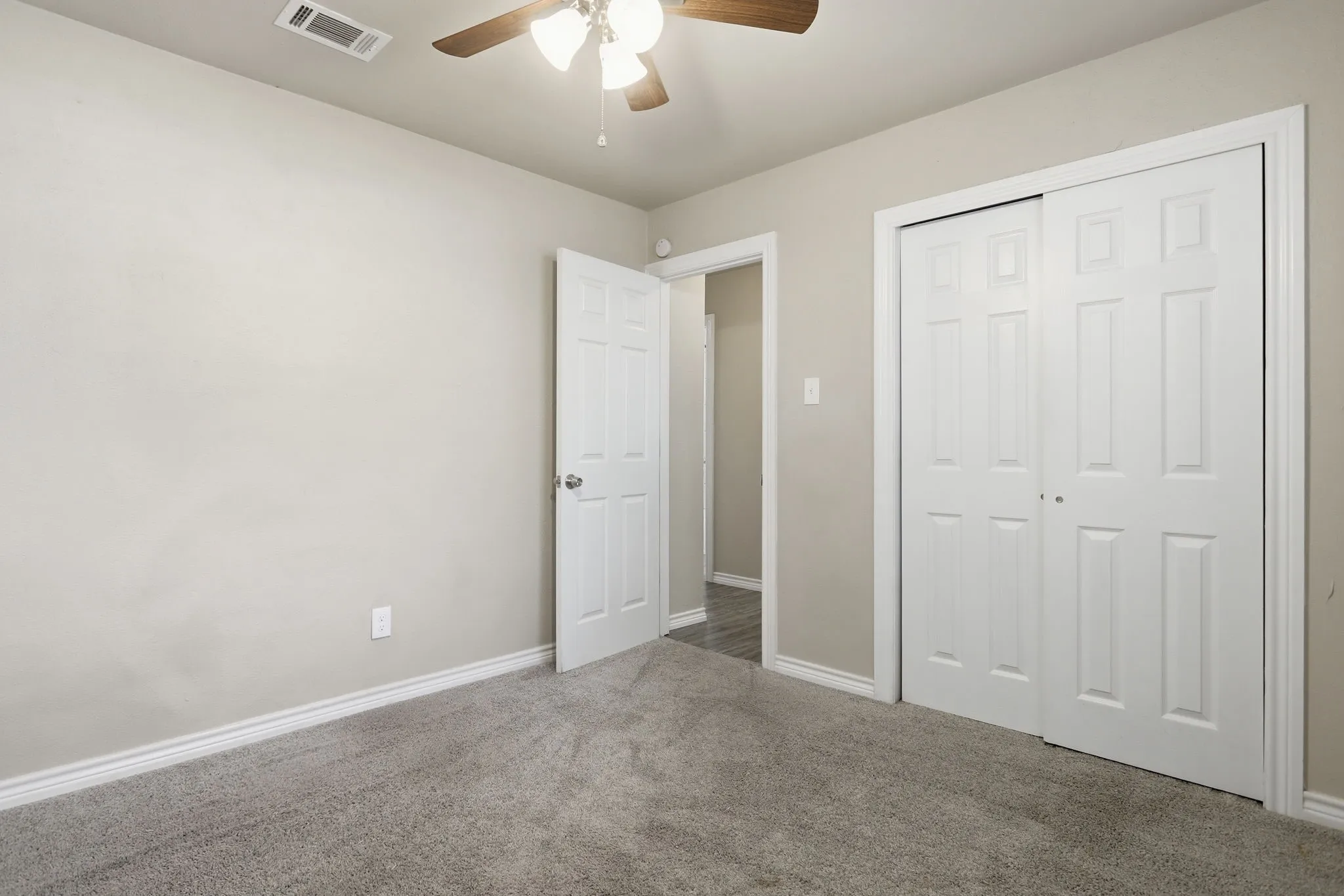 Wall-to-wall carpeting in a neutral tone, complemented by light-colored walls and white trim