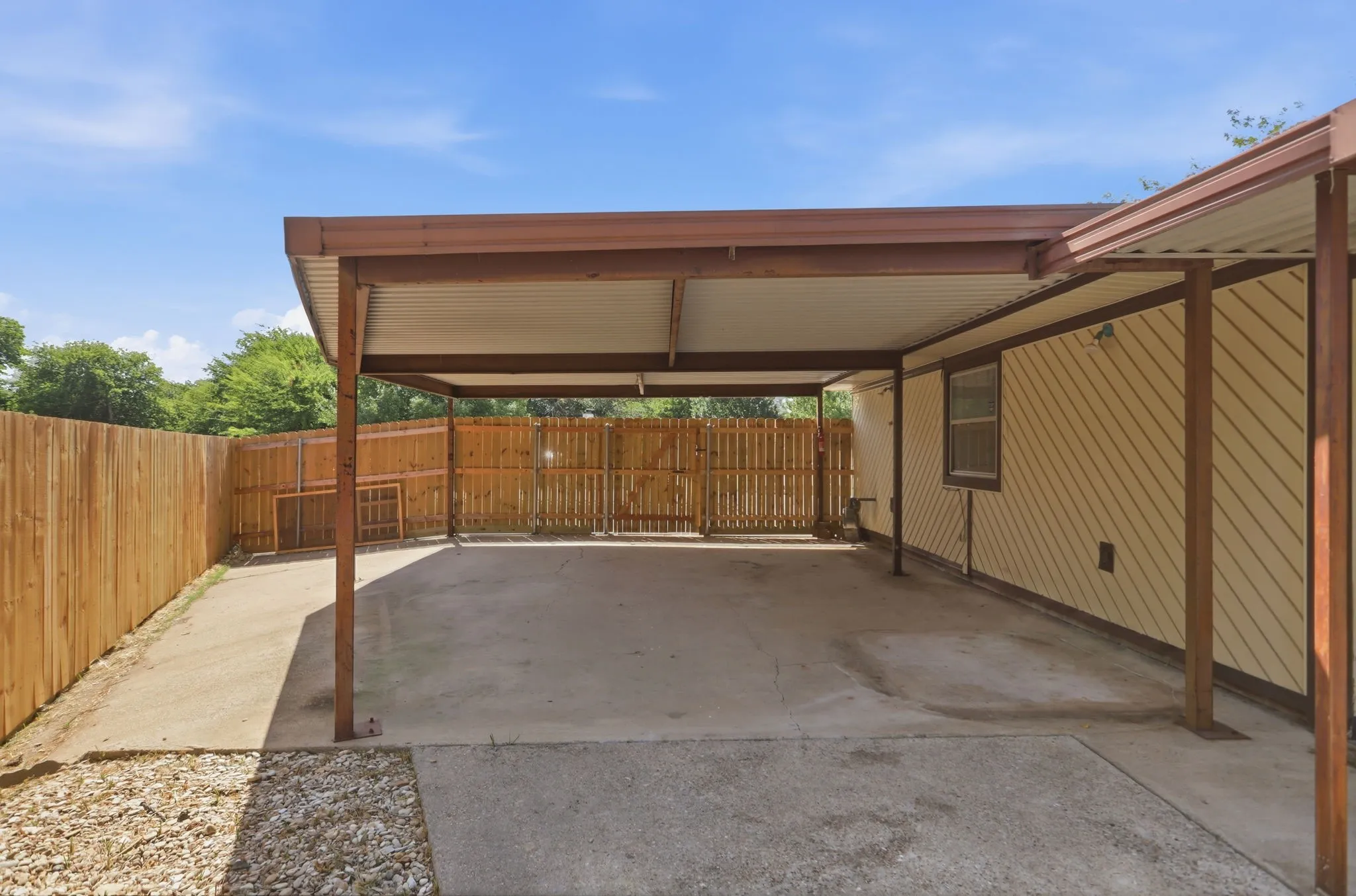 Covered carport structure with a concrete pad and metal roof
